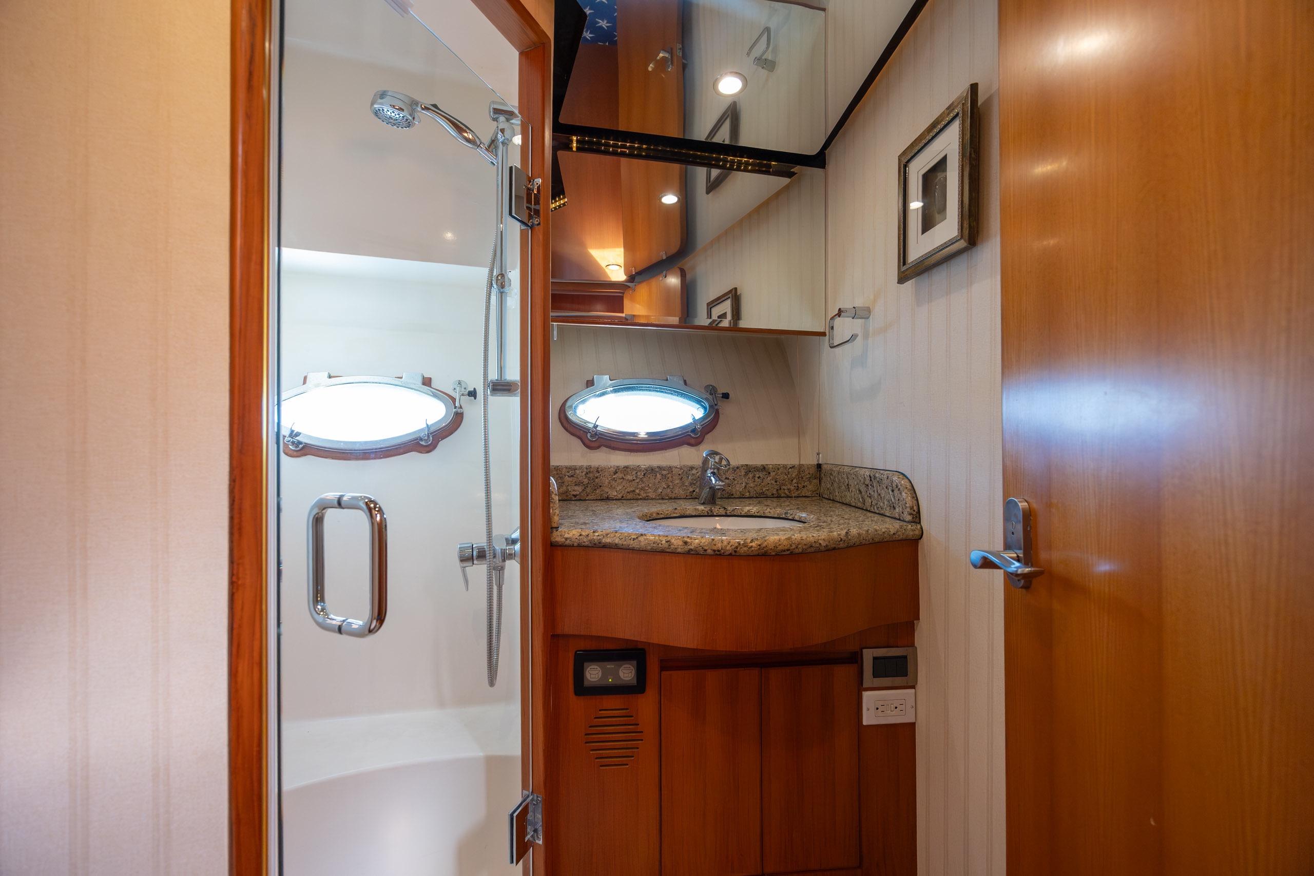 Luxurious bathroom in 2005 Ocean Alexander 52 Sedan yacht with shower and granite countertop.