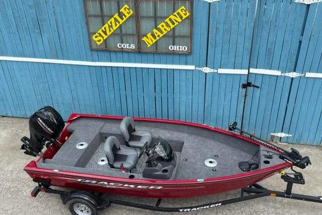 2025 Tracker Super Guide V-16 SC boat in front of blue garage, Sizzle Marine sign.