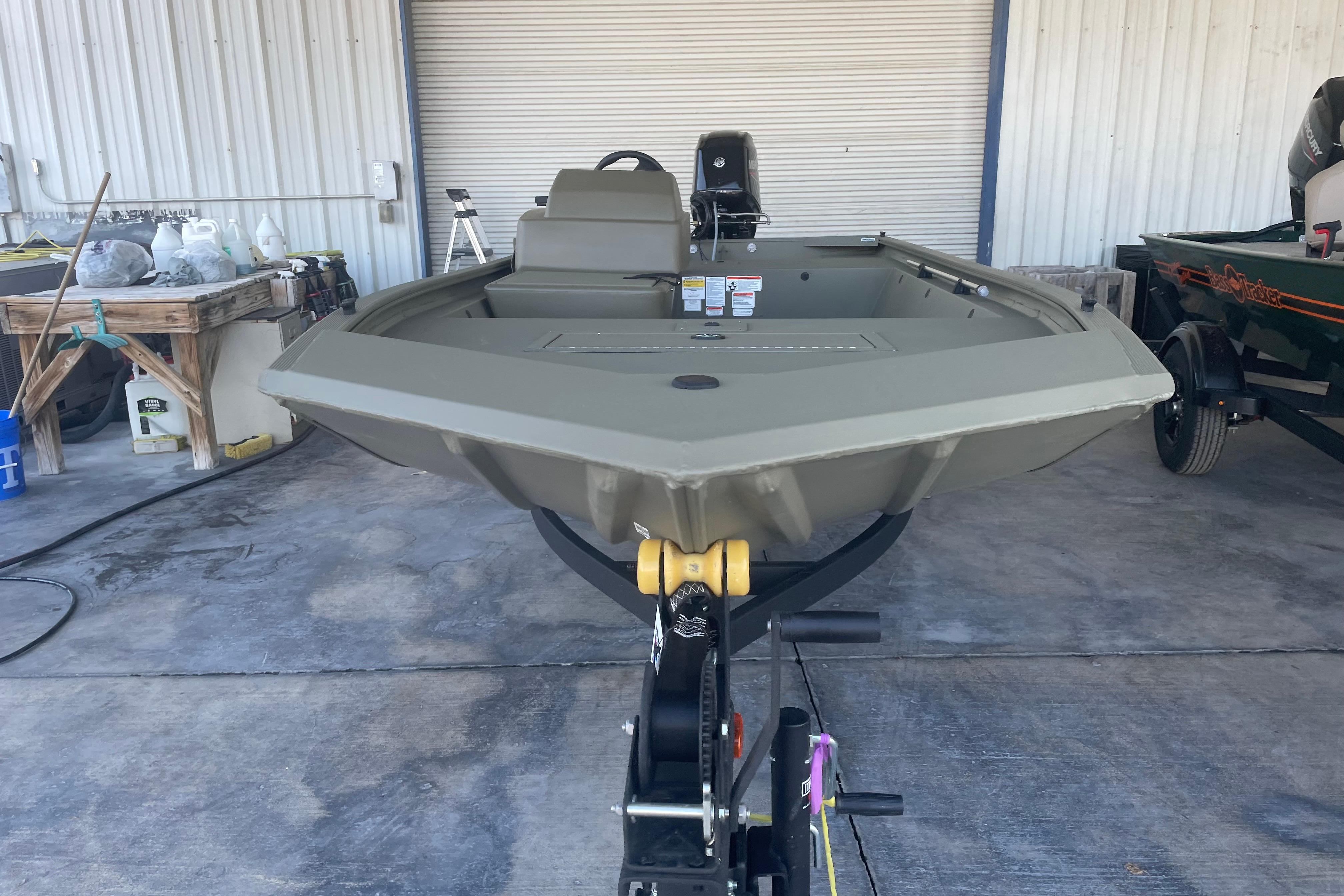 2026 Tracker Grizzly 1648 SC boat on trailer in a garage setting.