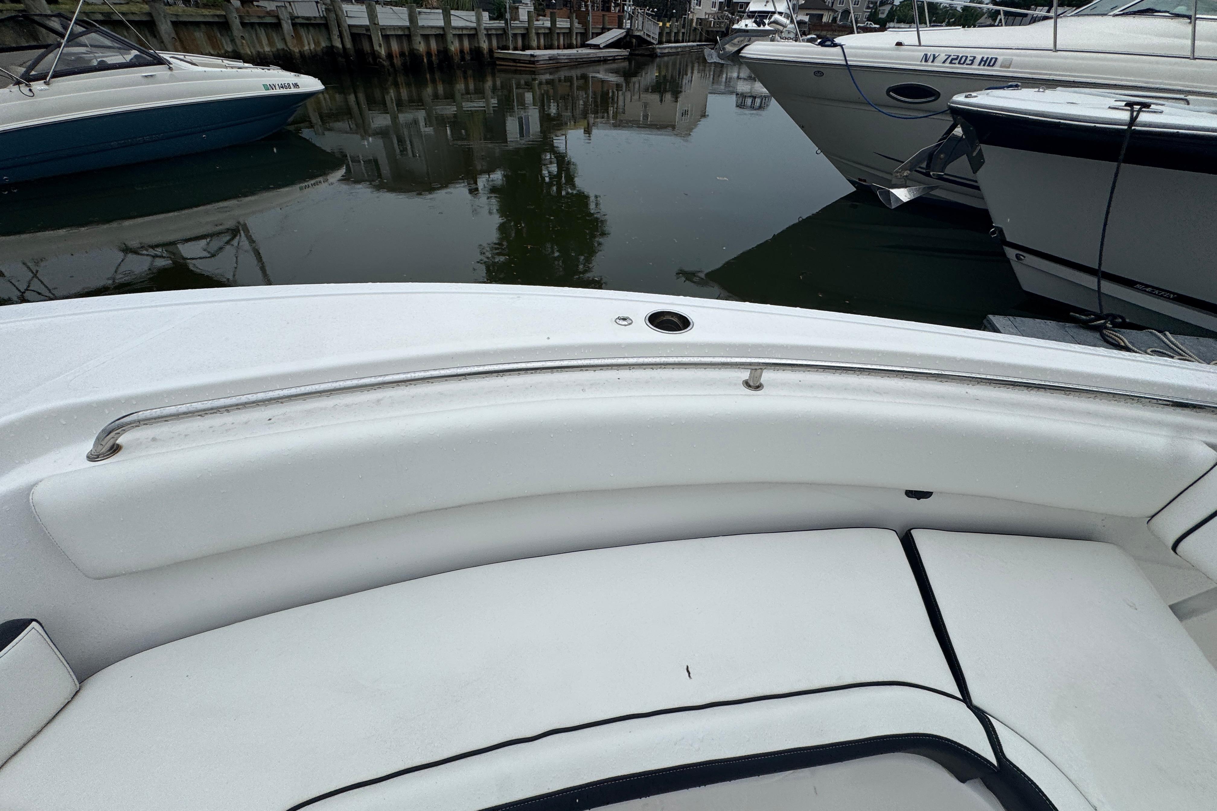 2022 Tidewater 232 SS boat interior with white seating, docked near other boats.