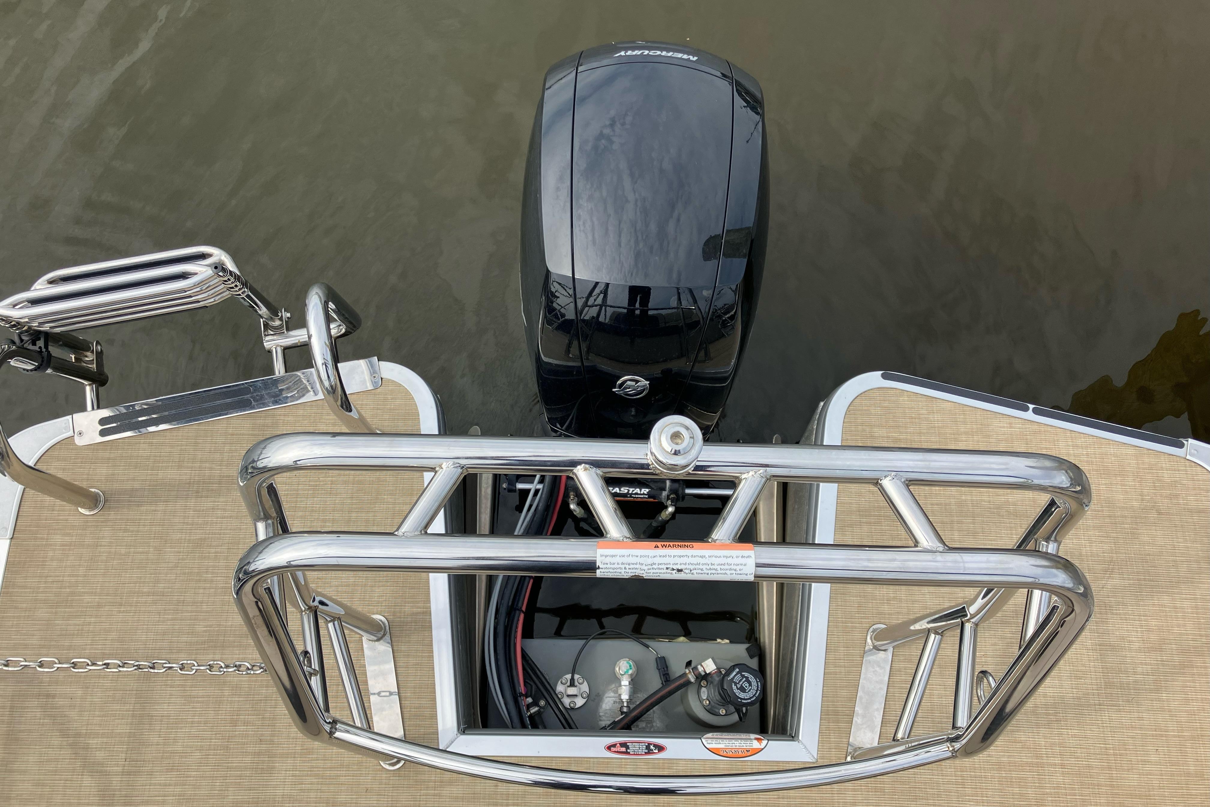 2024 Harris HCX23 boat with Mercury outboard motor and stainless steel railing.