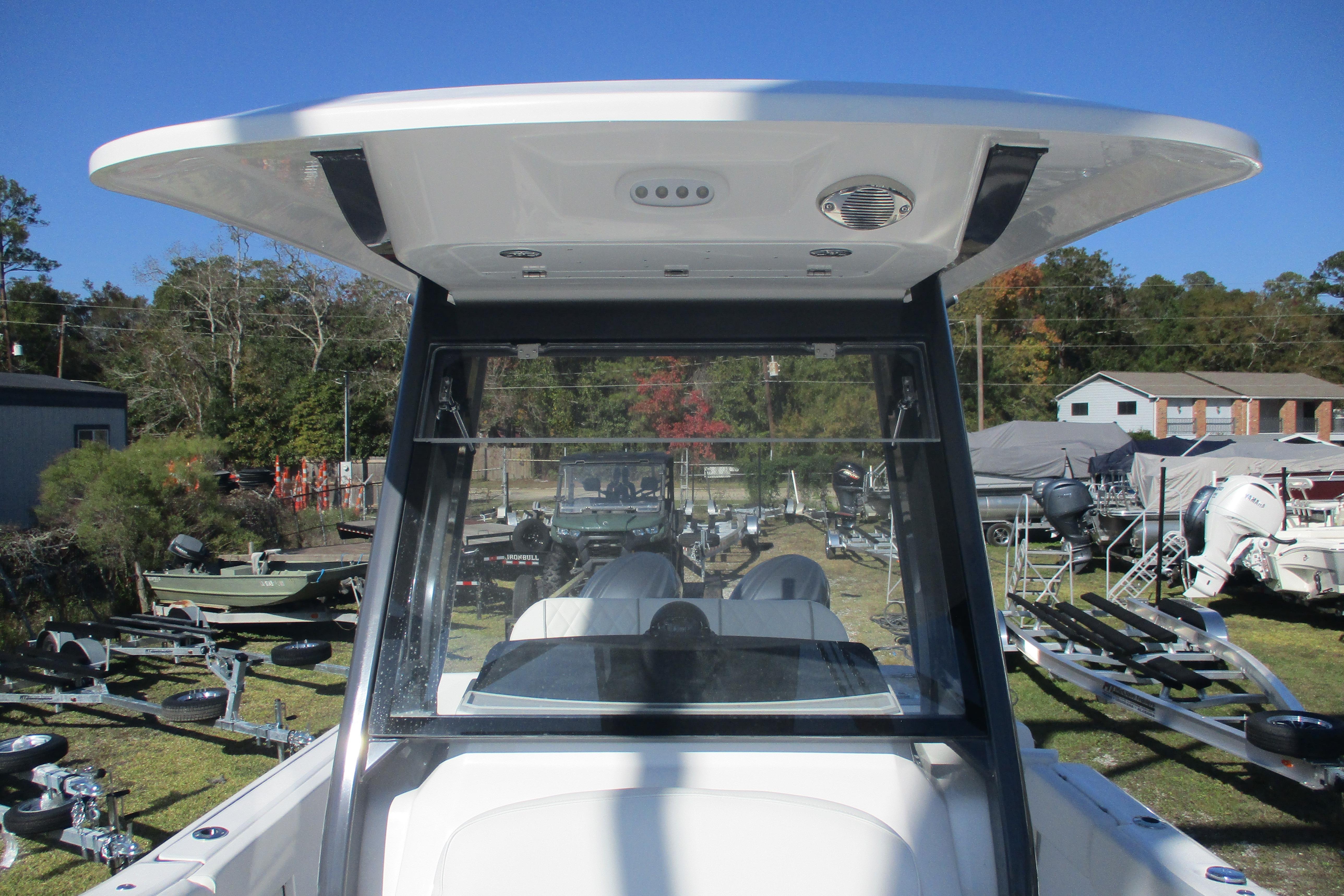 2026 Sea Fox 268 Commander boat, view of helm and T-top, parked outdoors.