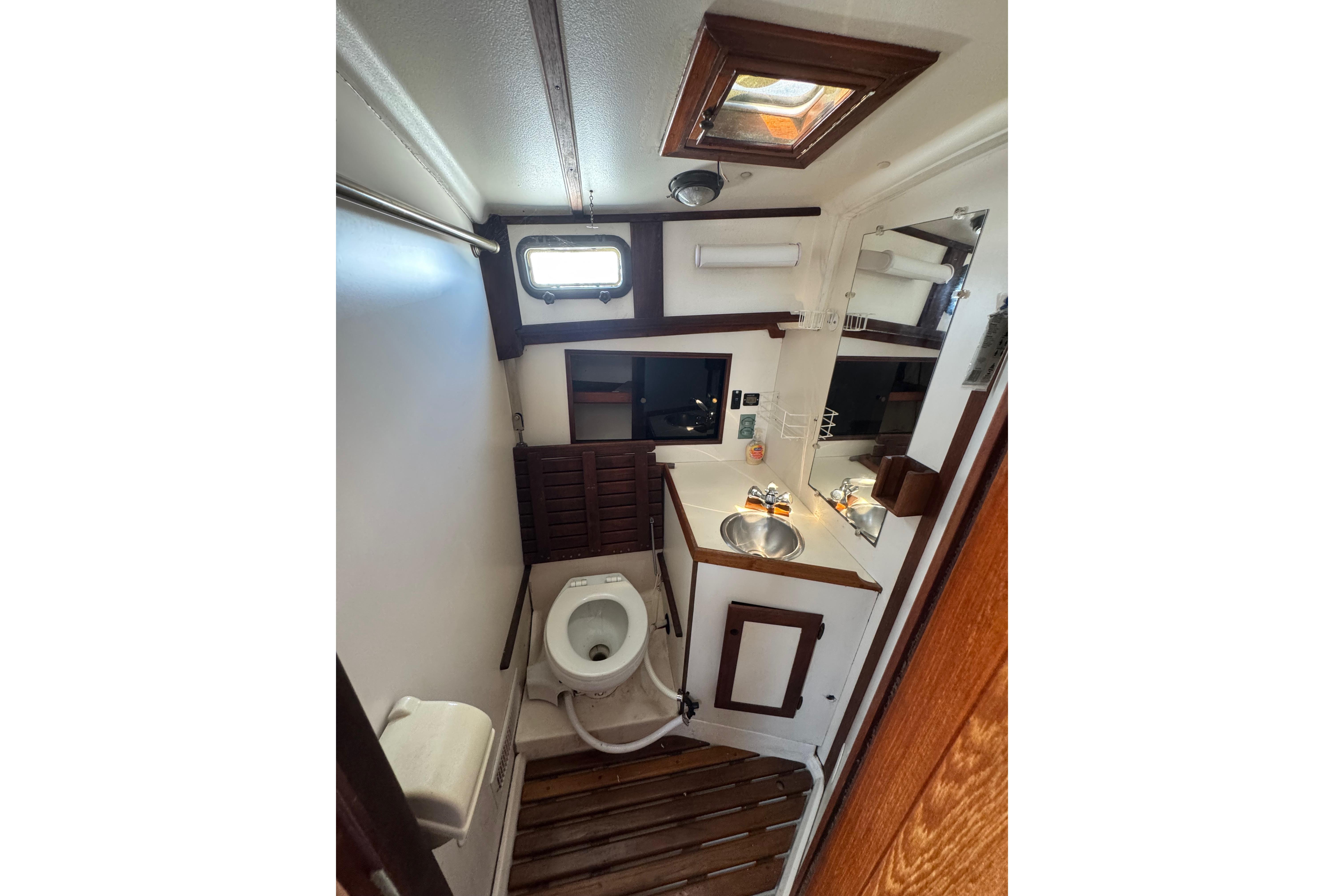 1989 Cape Dory 30 Motorsailer bathroom with wooden accents and compact design.