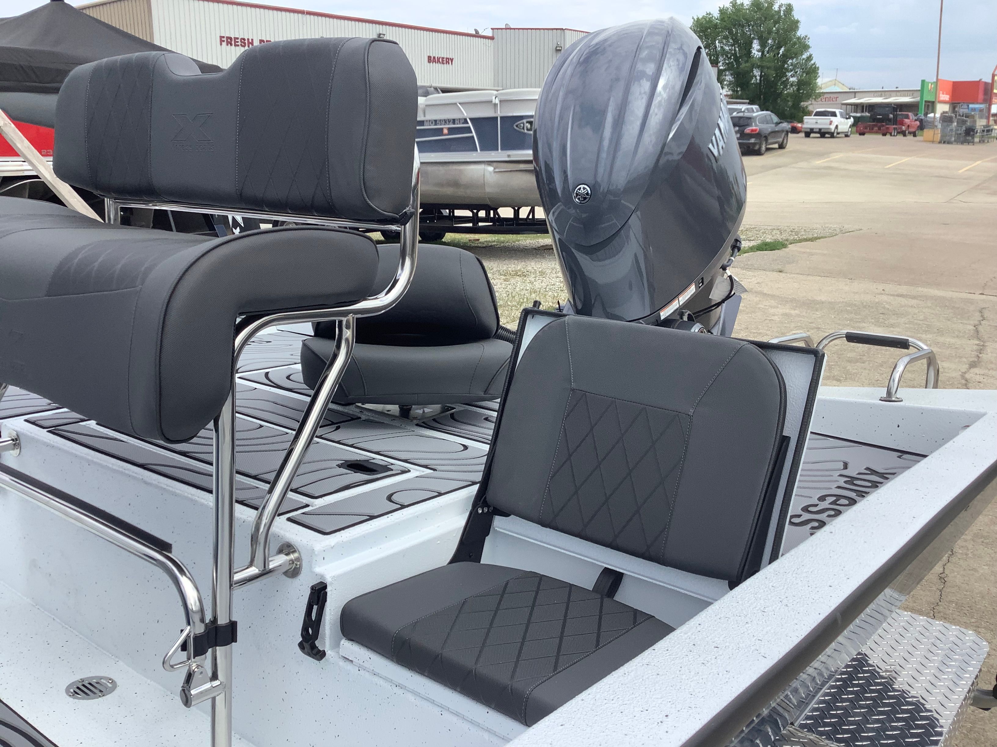 2026 Xpress H22B Bay boat with gray seats and outboard motor.