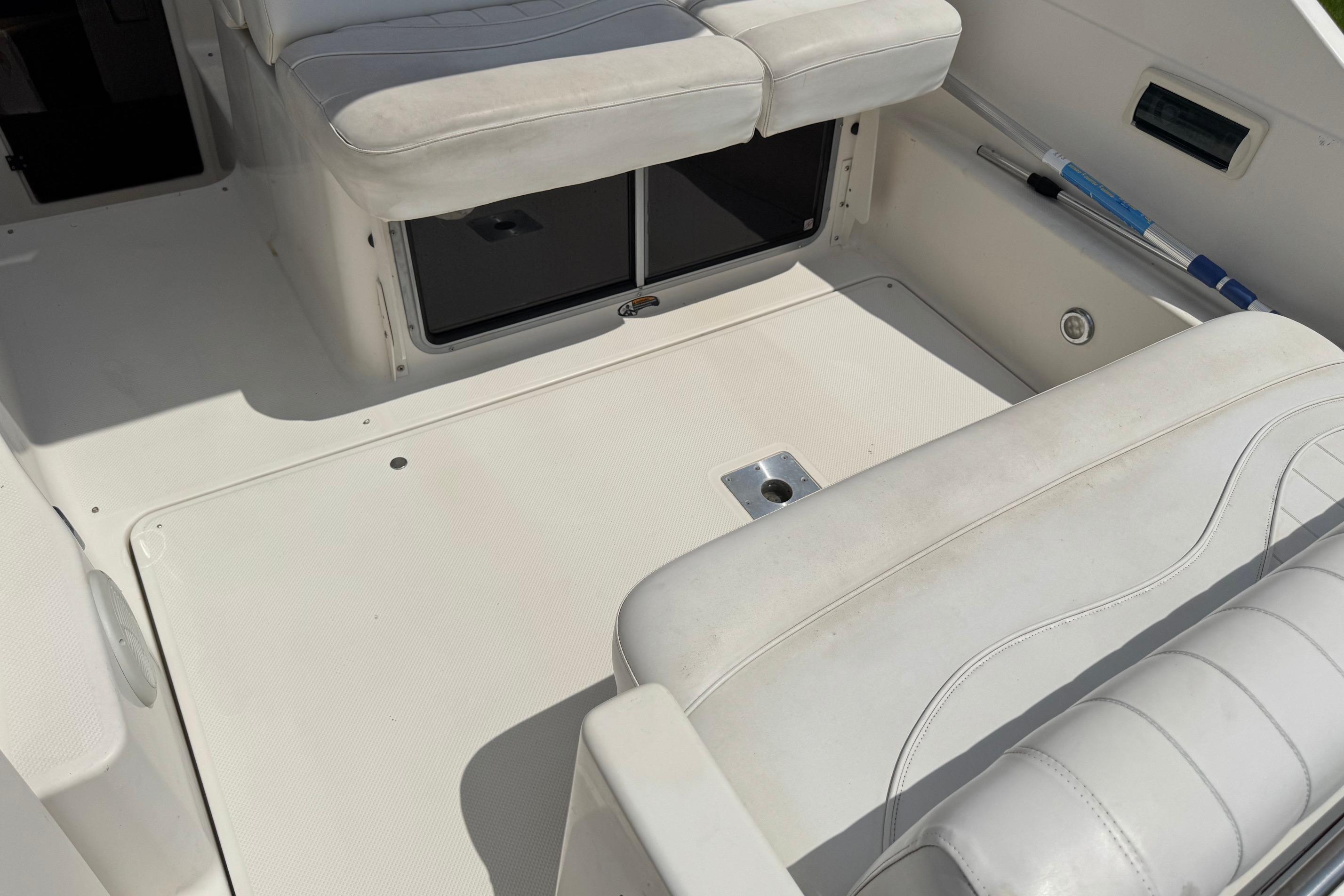 Interior of a 2000 Maxum 2400 SCR boat, featuring white seating and storage compartments.
