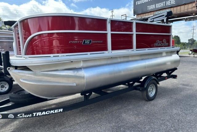 2026 Sun Tracker Party Barge 16 DLX pontoon boat on trailer, red and silver design.