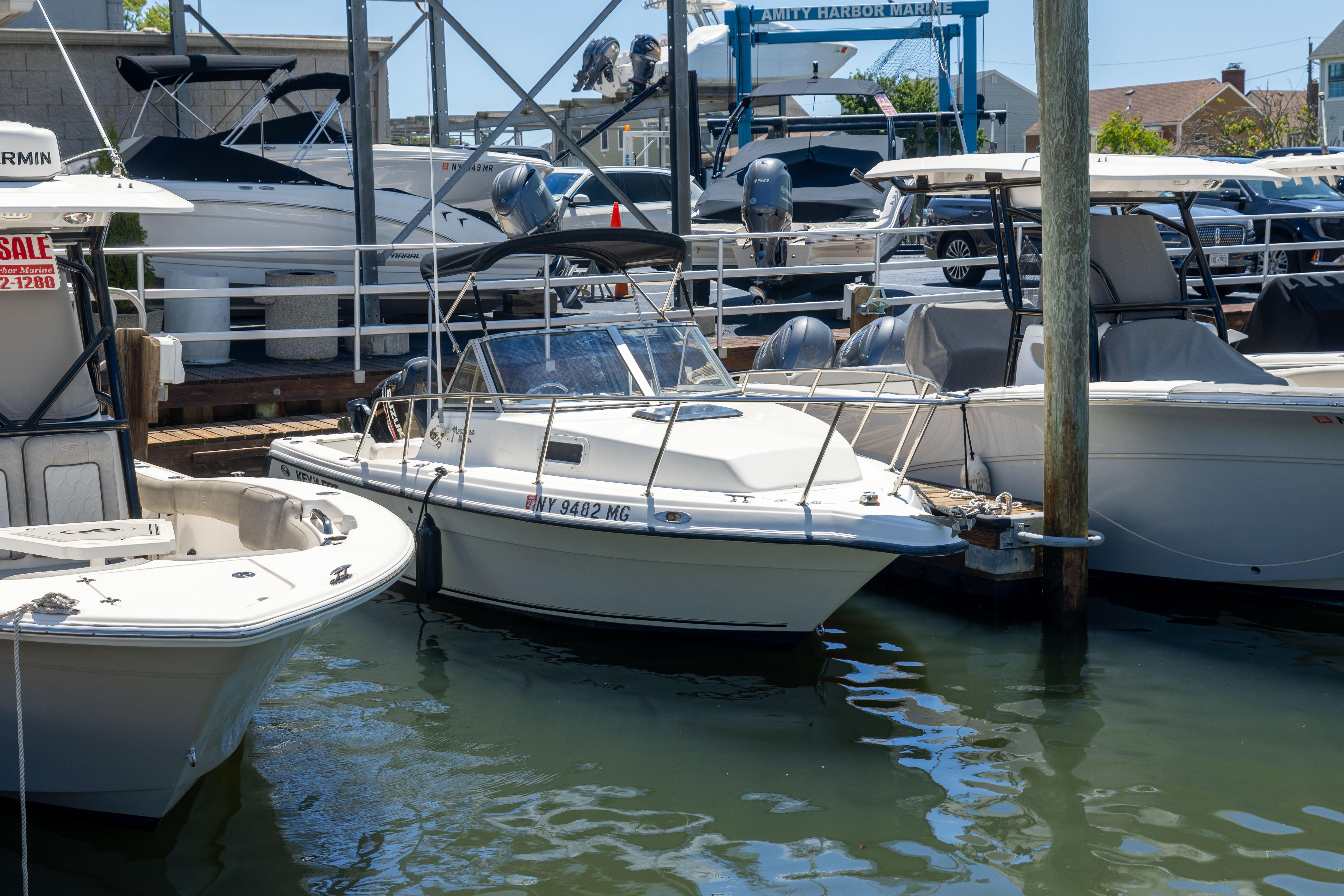 A 2012 KEYWEST 2020 WA boat docked at a marina, surrounded by other vessels.