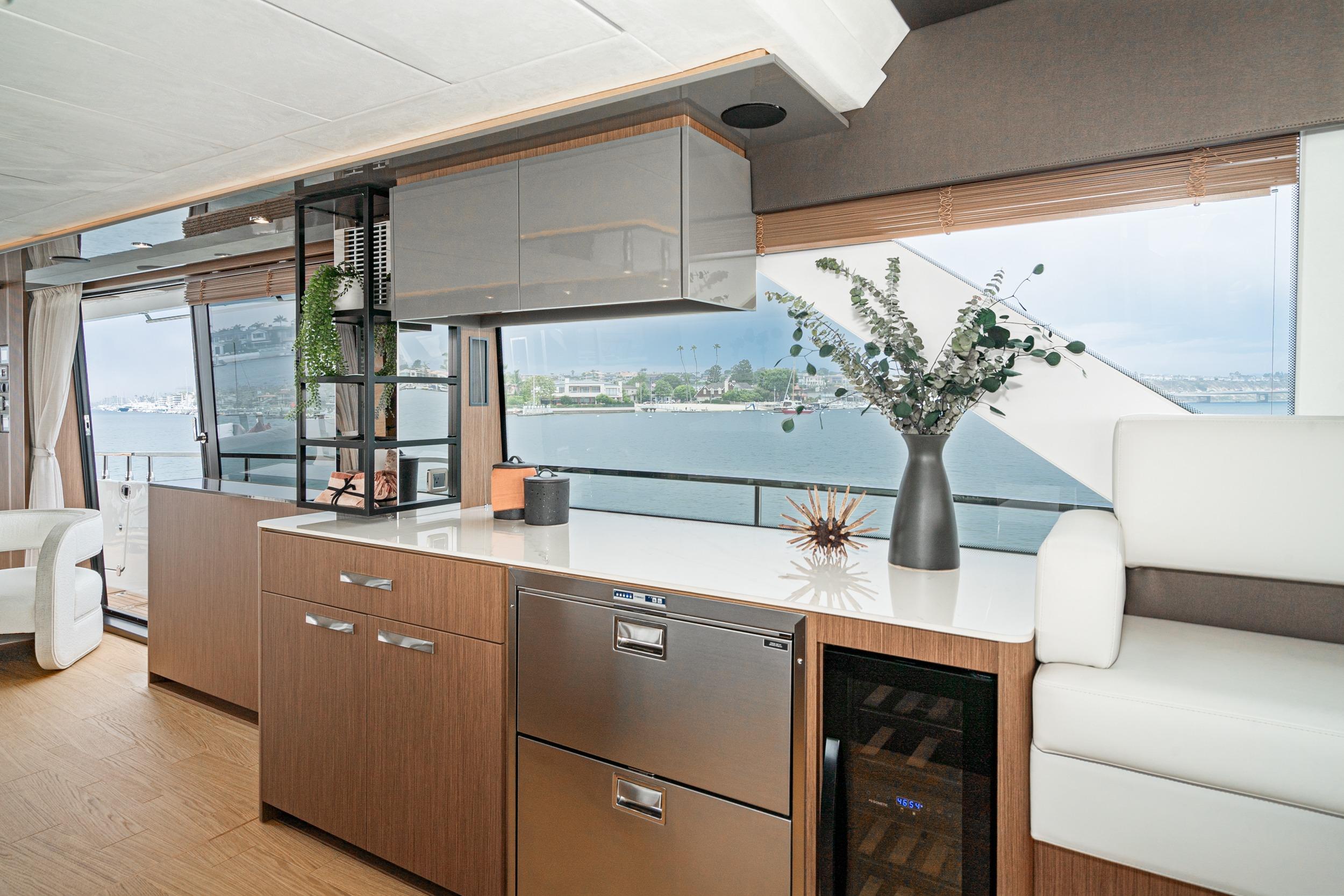 Luxurious 2024 Prestige X60 yacht interior with modern kitchen and scenic ocean view.