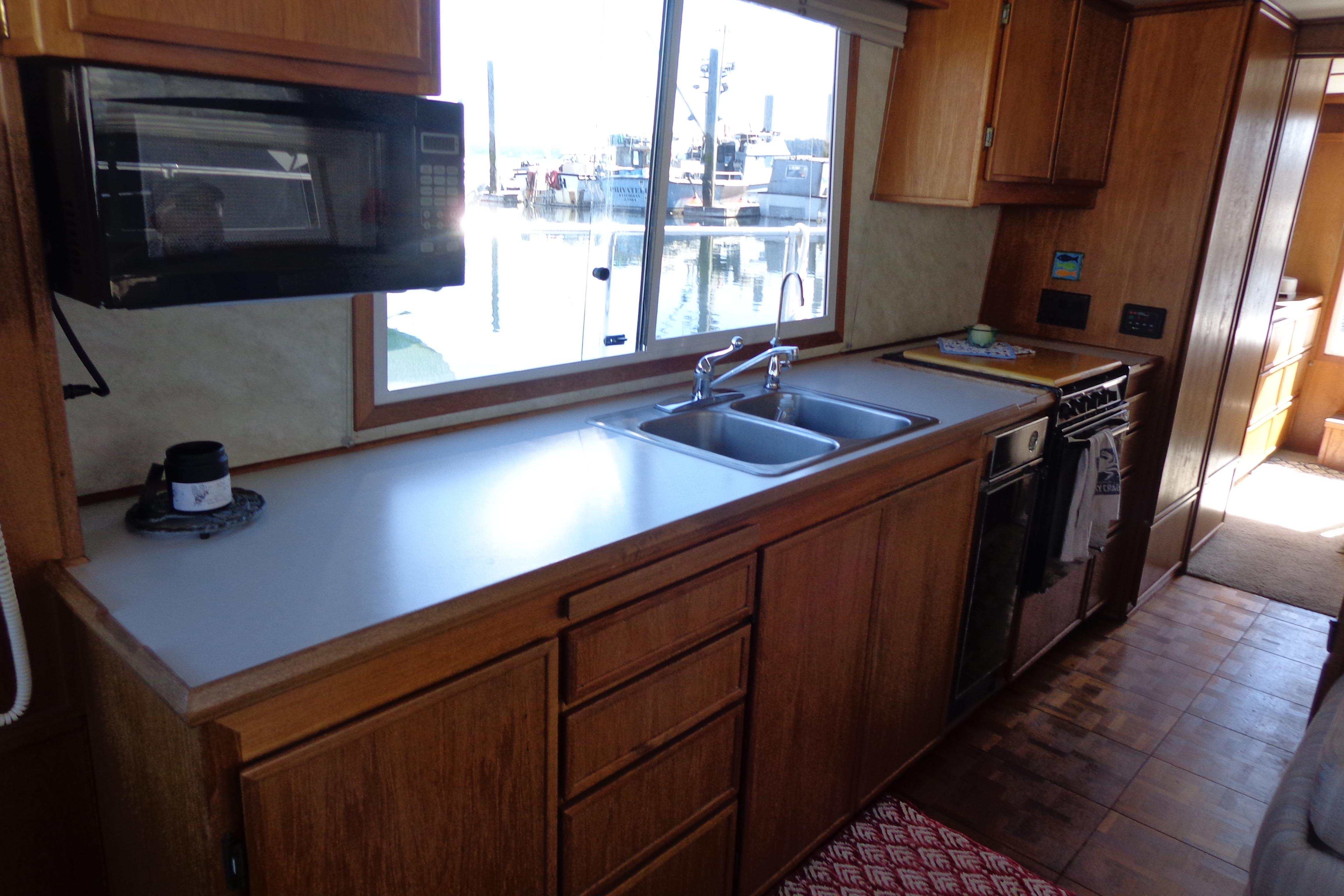 1992 Cruise-A-Home Corsair 4200 kitchen with wooden cabinets, sink, and appliances.