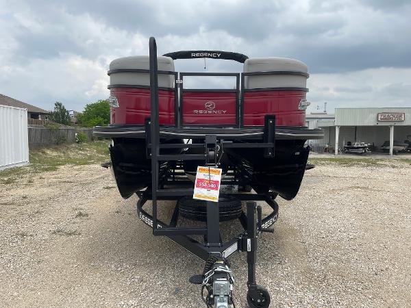 2023 Regency 250DL3 pontoon boat on trailer, displayed outdoors under cloudy sky.