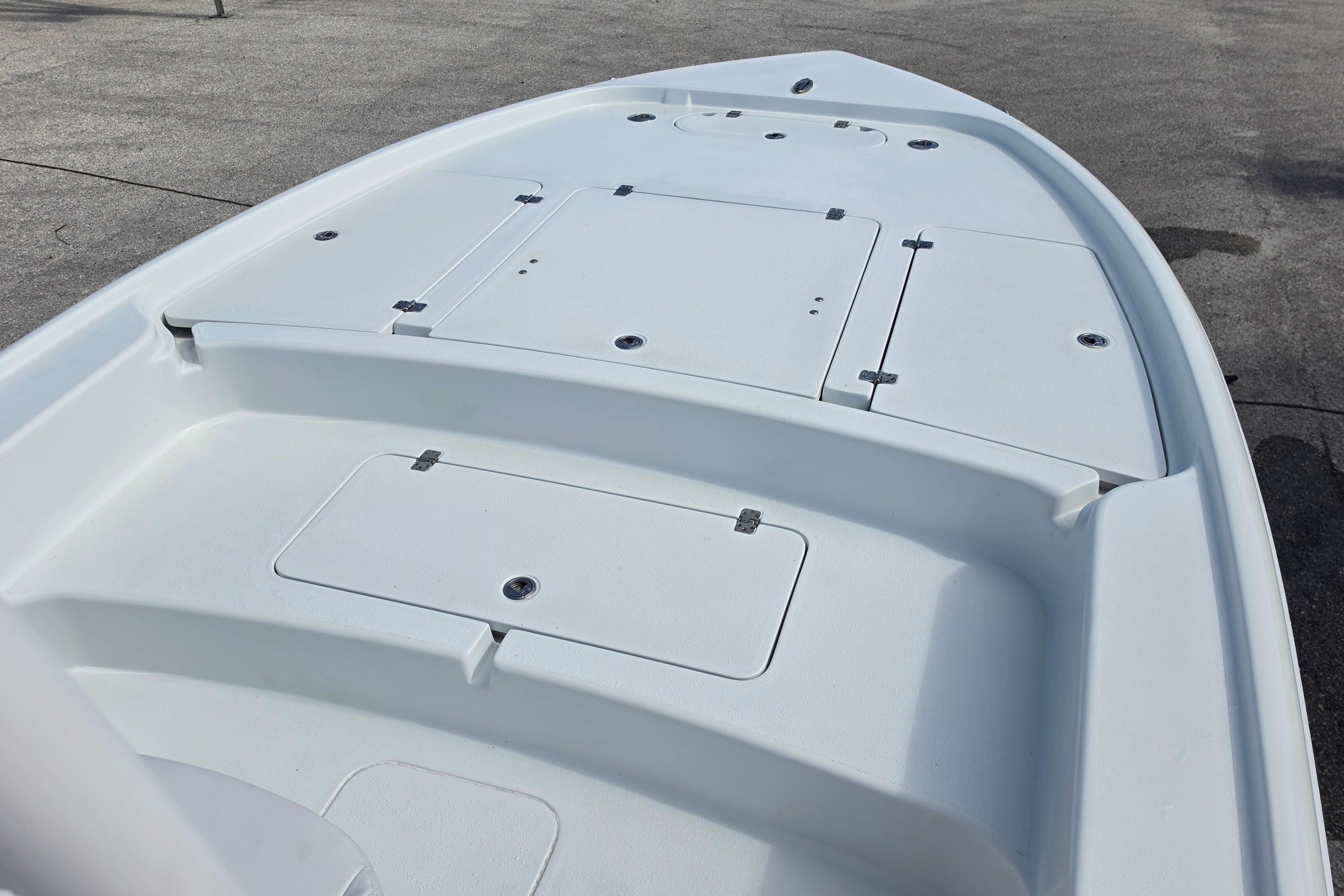 2026 Yellowfin 24 Bay CE boat deck with storage compartments, shown on a concrete surface.