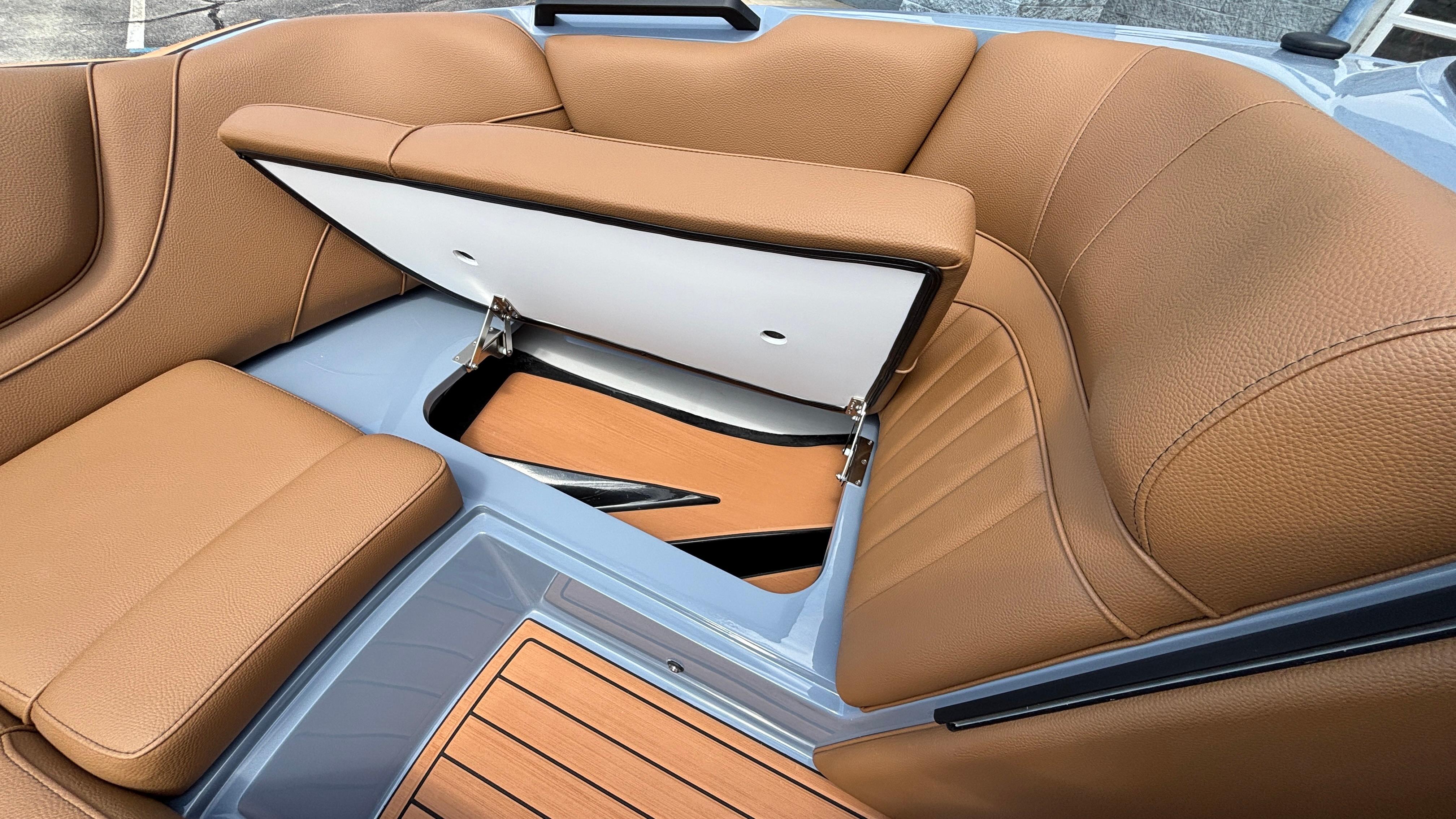 2025 MB B52 23 Alpha boat interior with tan leather seats and storage compartment.
