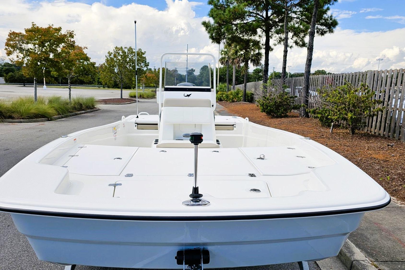2026 Mako Pro Skiff 19 CC boat parked outdoors, showcasing spacious deck and sleek design.