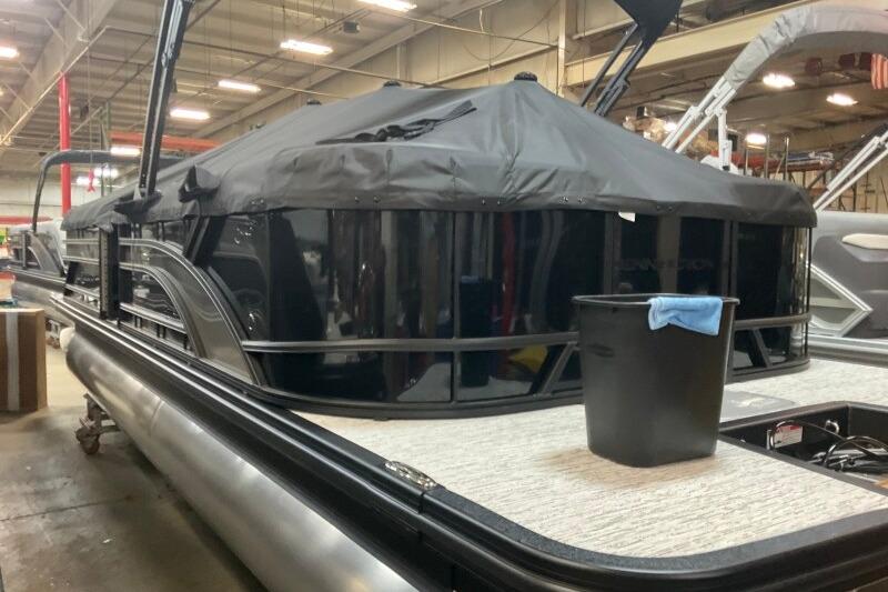2026 Bennington 23 SSRSF pontoon boat in a warehouse, covered and ready for transport.