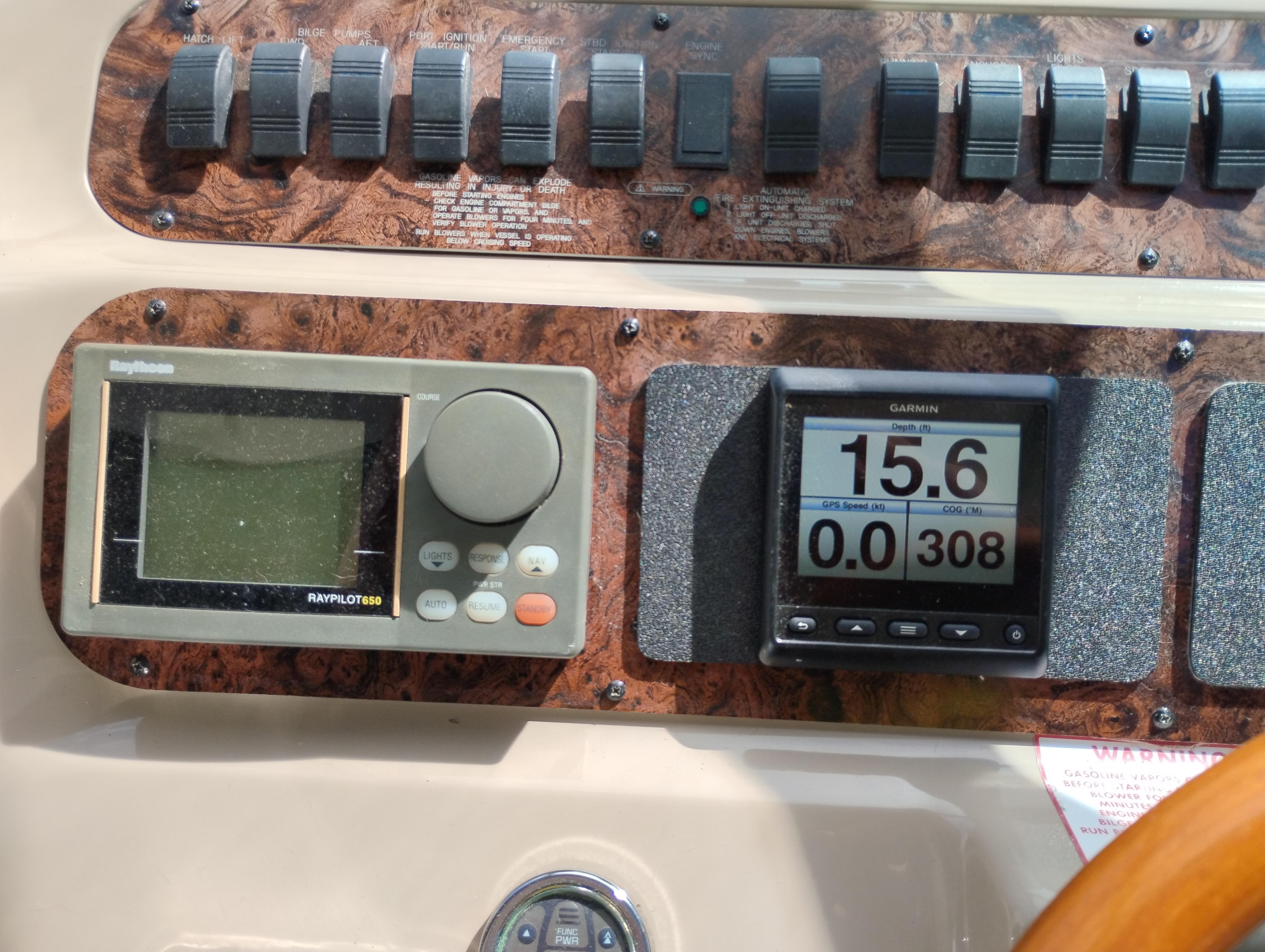 Control panel of a 1999 Sea Ray 400 Sundancer with navigation instruments and switches.
