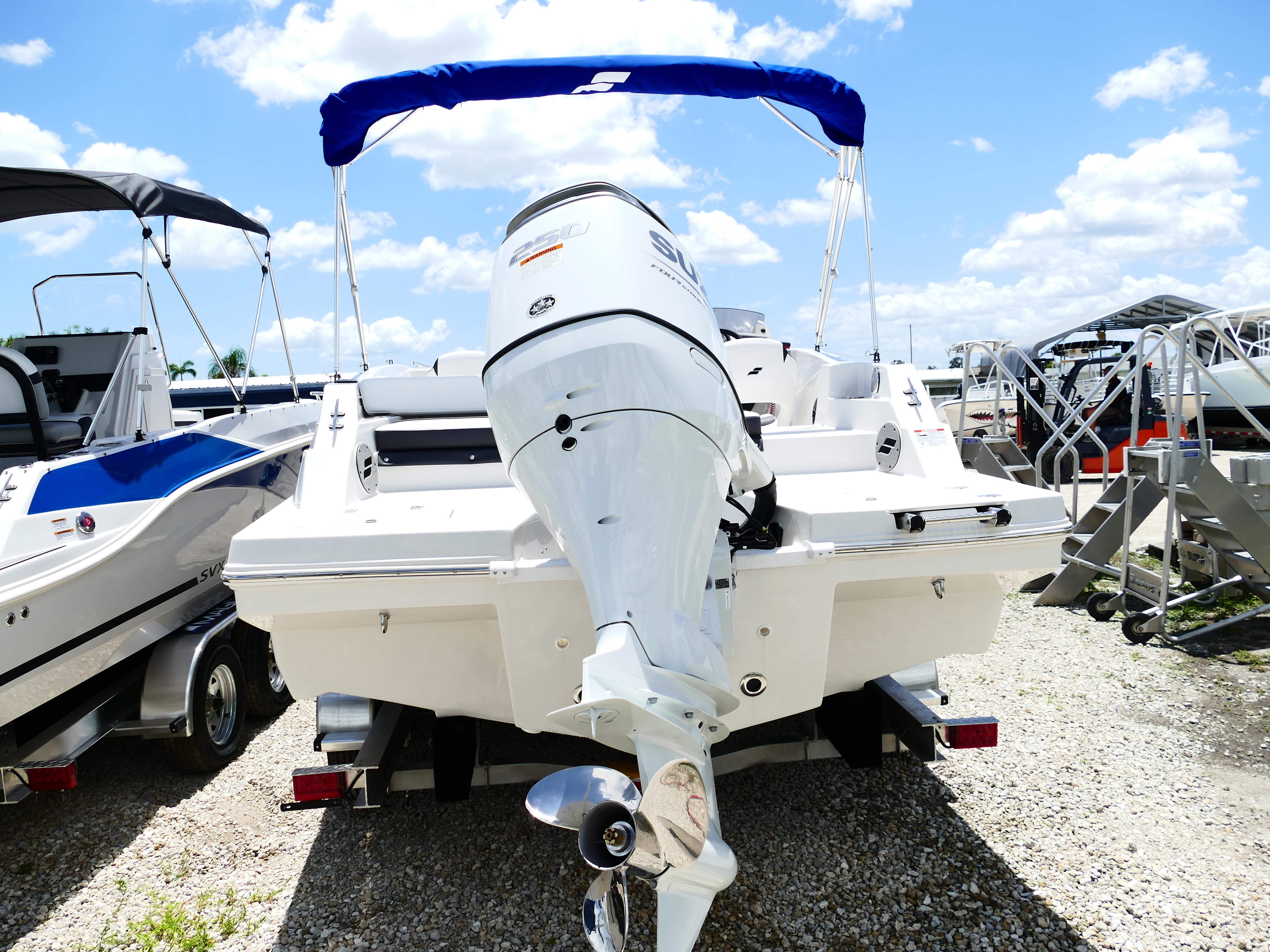 2026 Starcraft SVX 231 OB DH boat with outboard motor, parked on gravel under blue sky.