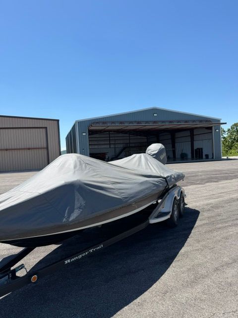 2011 Ranger Z520 Comanche boat covered, parked outside warehouse.