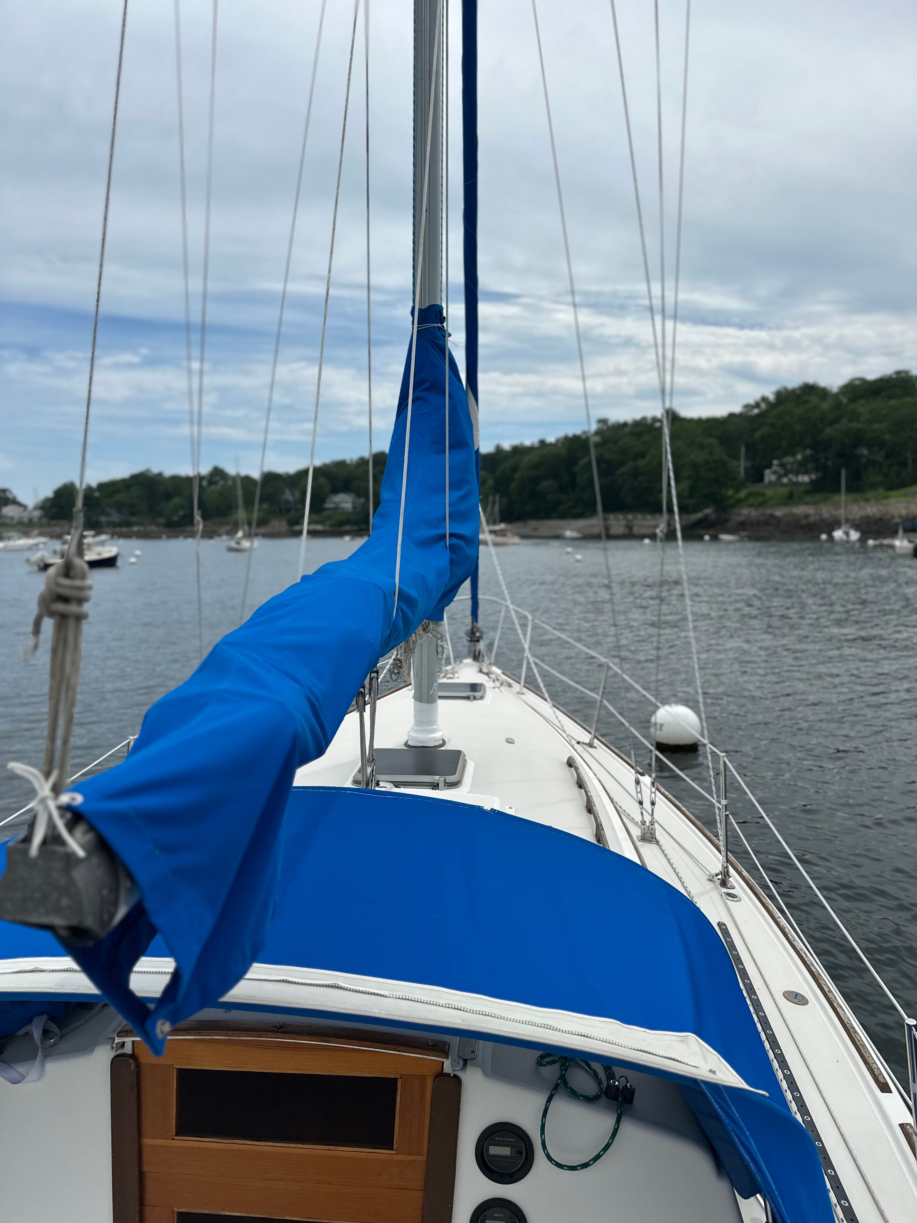 A 1984 Pearson 303 sailboat anchored in a calm bay.