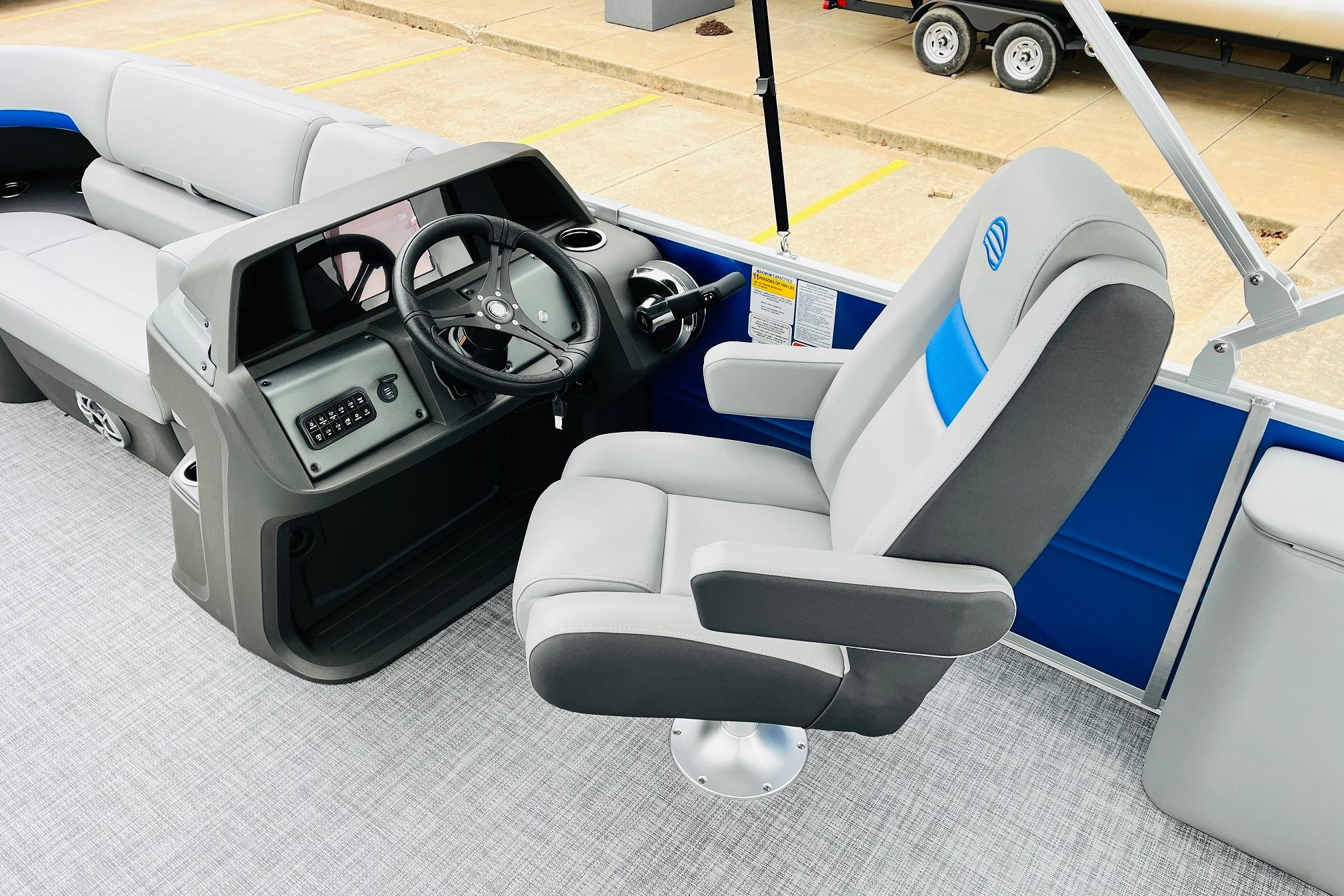2026 Sun Tracker Party Barge 22 RF DLX interior with captain's chair and steering console.