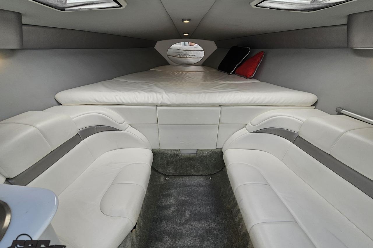 Interior of a 2005 Formula 271 FASTech boat with white seating and a cozy bed.