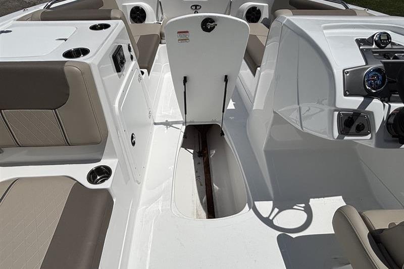 2026 Tahoe 2150 boat interior with open storage compartment and beige seating.