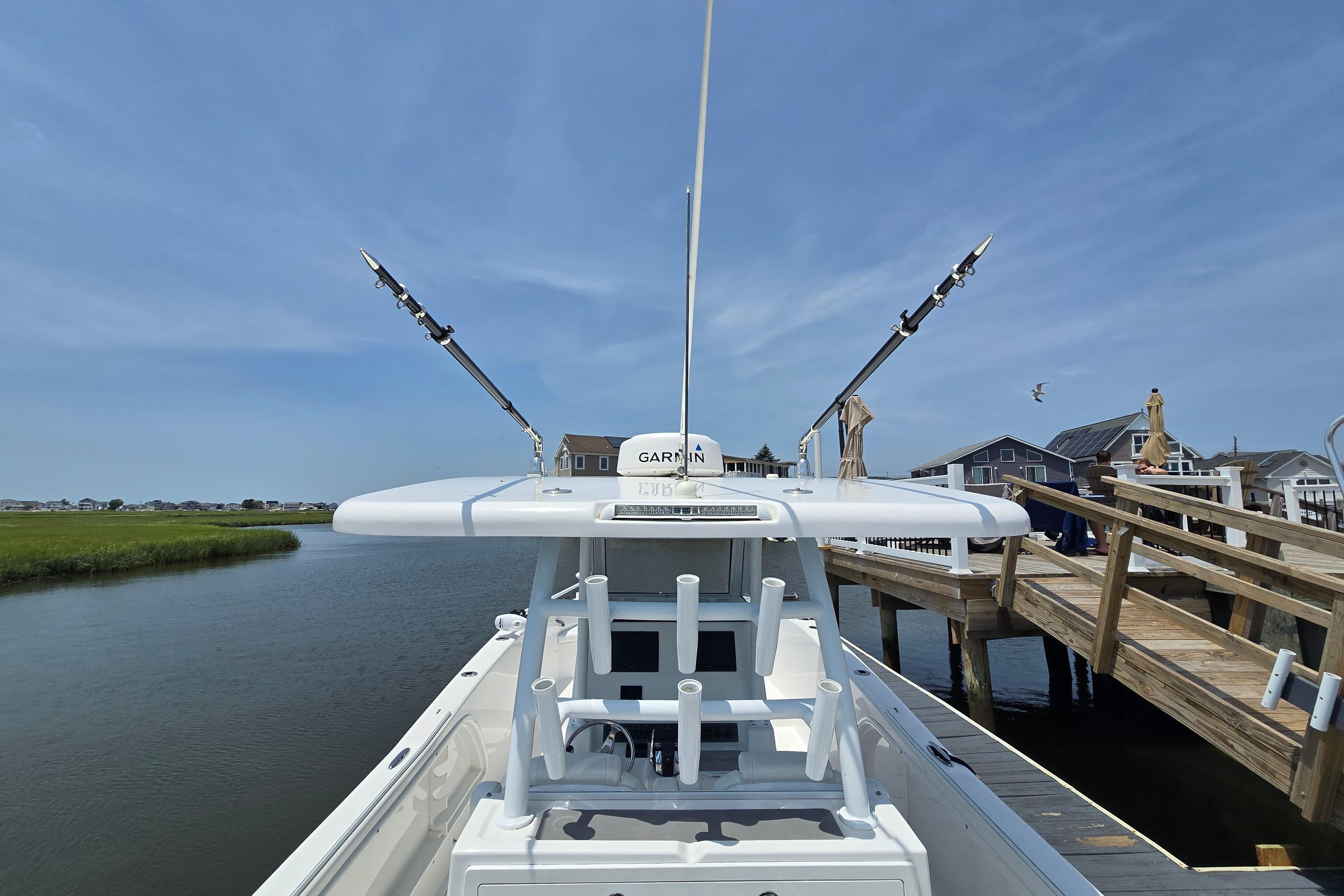 2021 Twin Vee 280 GFX CC boat docked, featuring fishing rods and Garmin equipment.