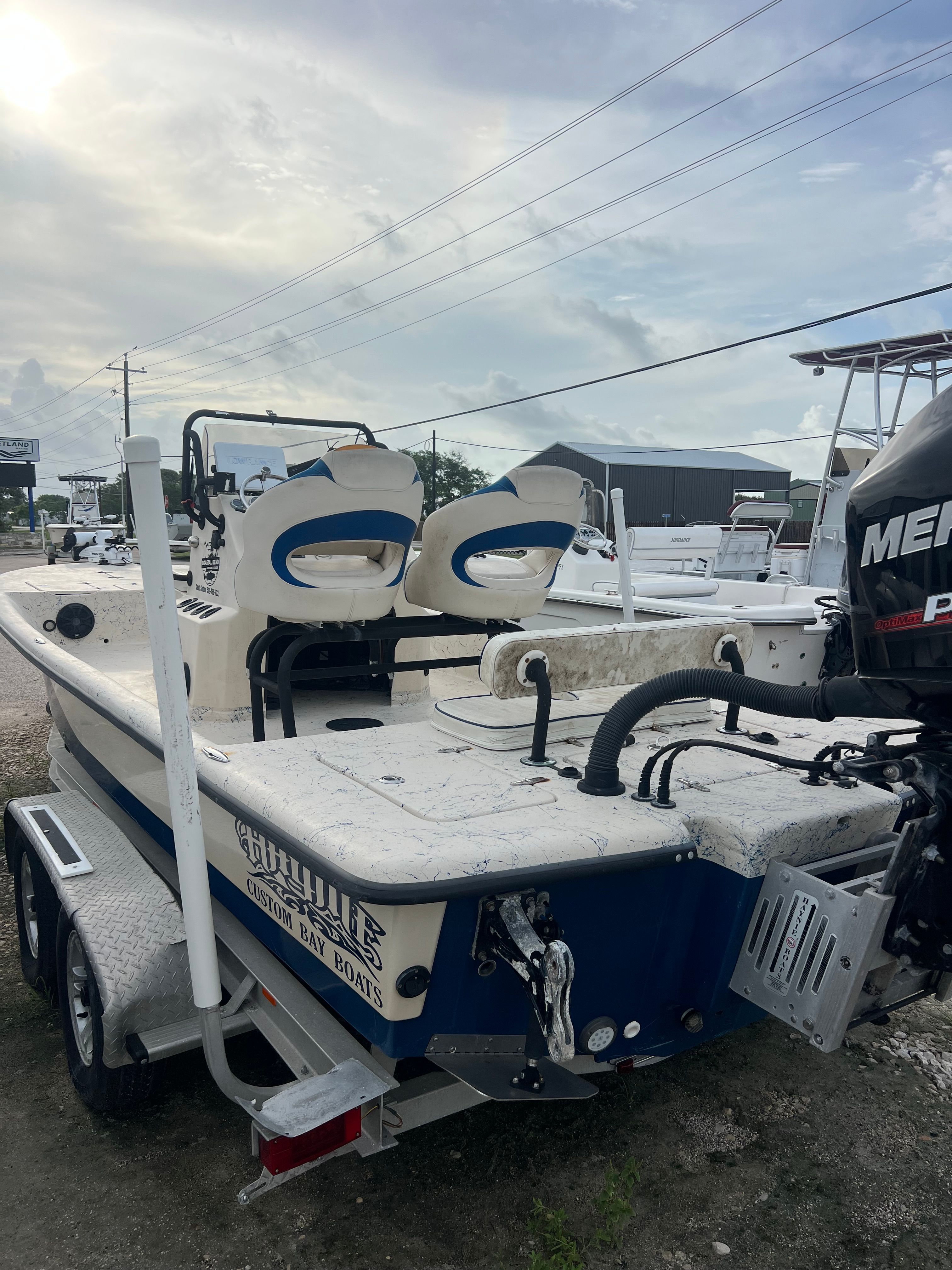 A 2014 Haynie boat on a trailer, featuring a Mercury engine and two seats.