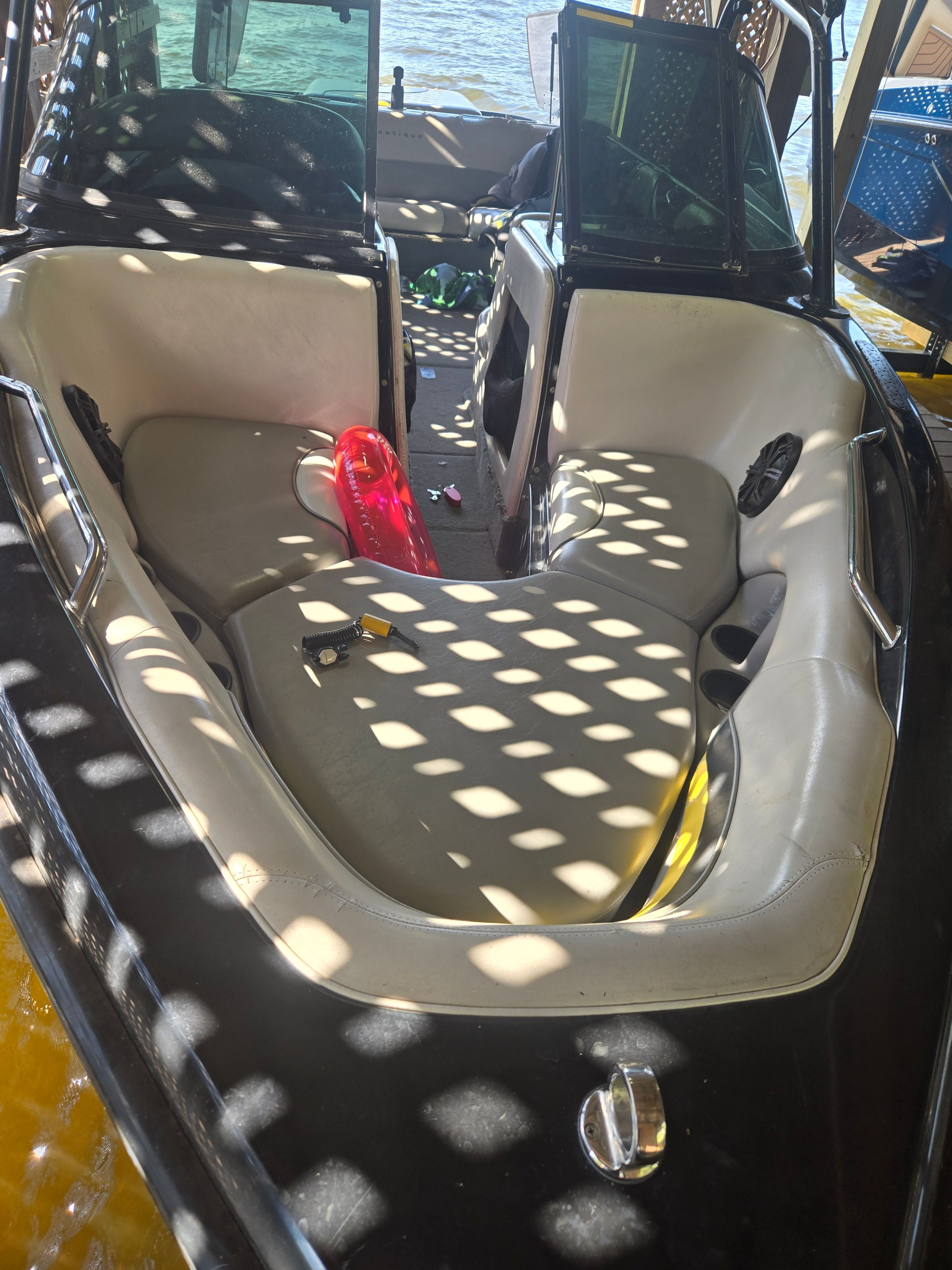 The image shows the cockpit of a 2003 Correct Craft Air Nautique boat with white seating.