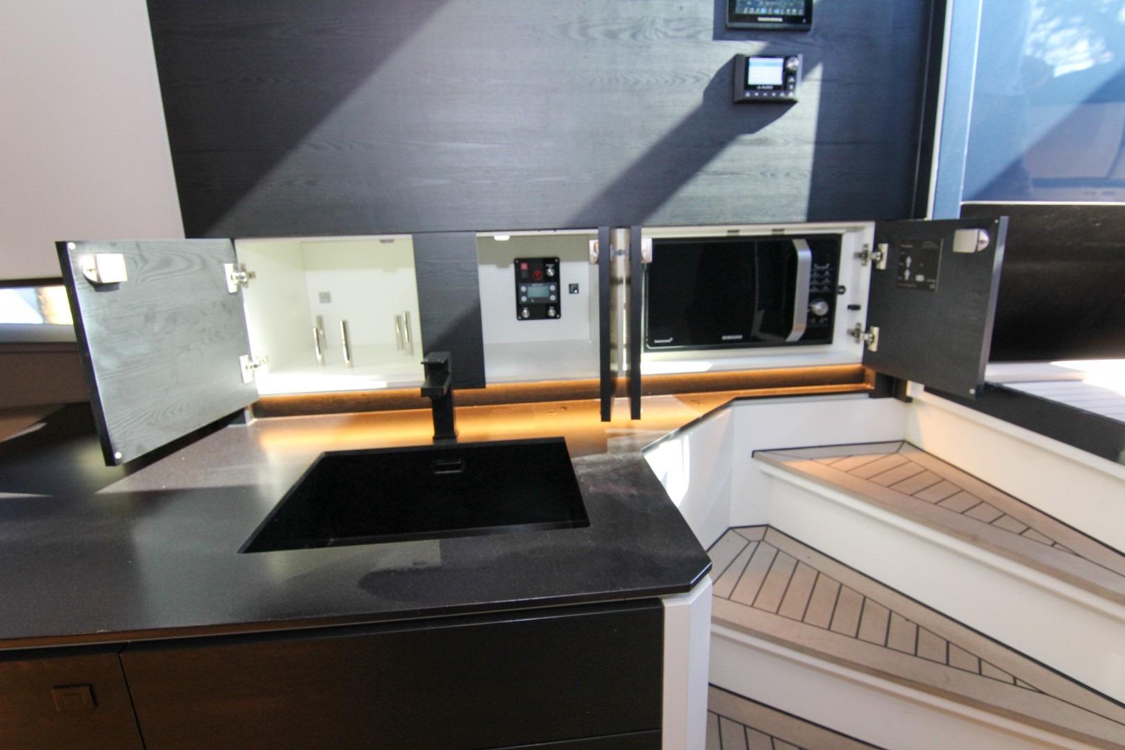 Modern kitchen area on 2022 Vanquish Yachts VQ45, featuring sleek cabinetry and appliances.
