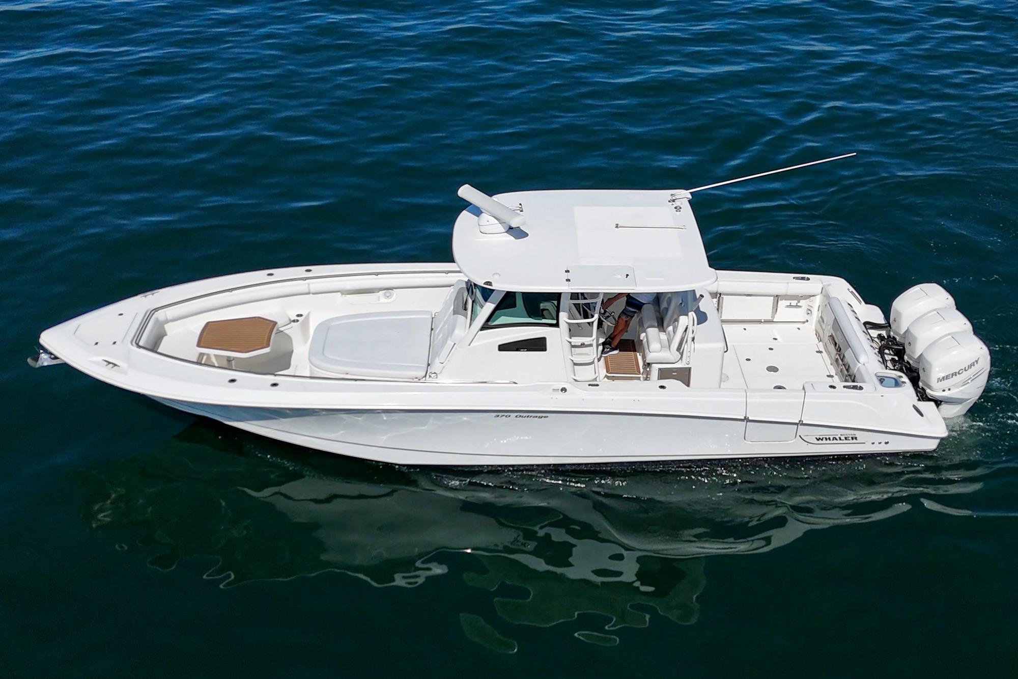 2015 Boston Whaler 370 Outrage boat cruising on clear blue water.