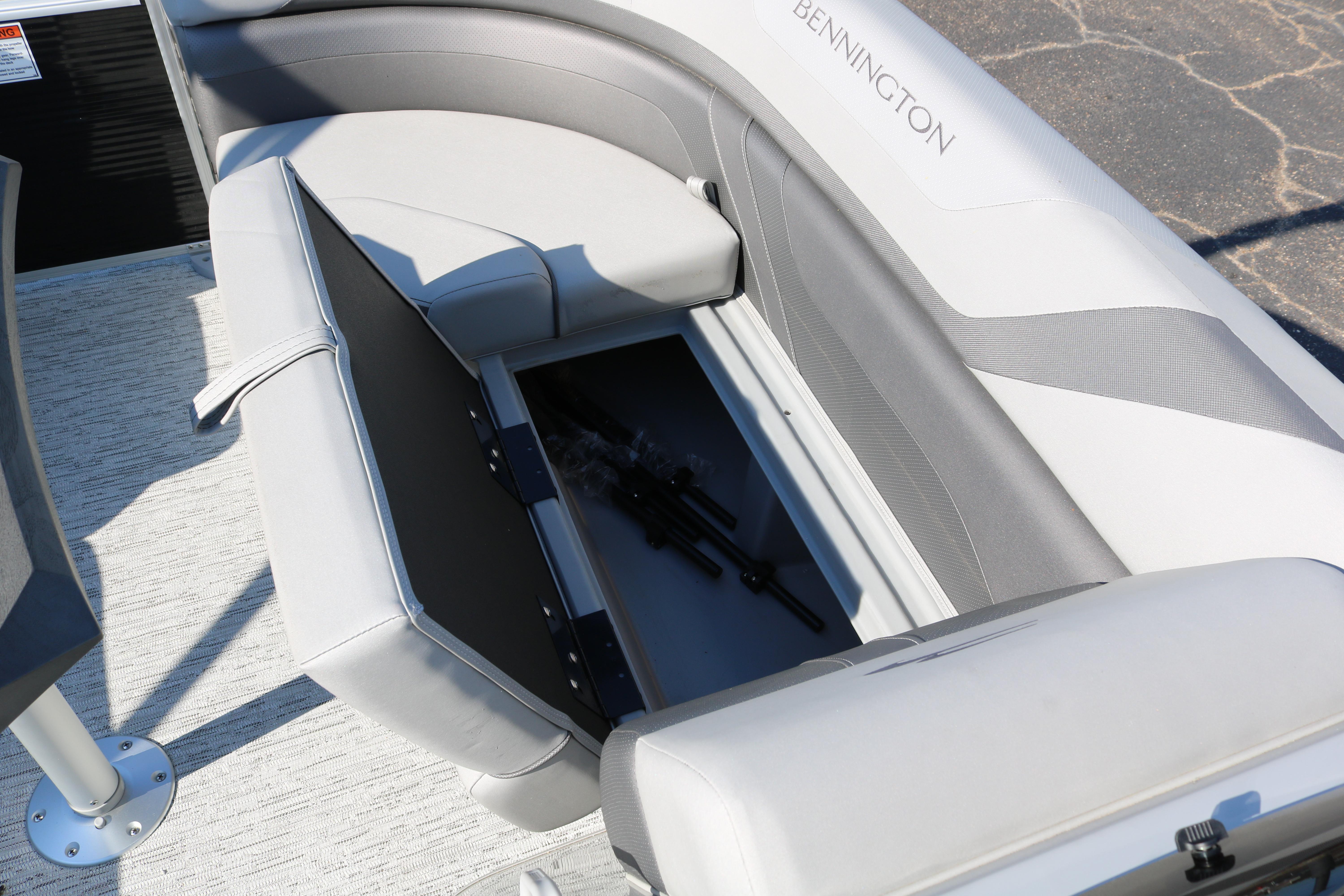 2026 Bennington 22SX Stern Radius boat with open storage compartment under gray seating.