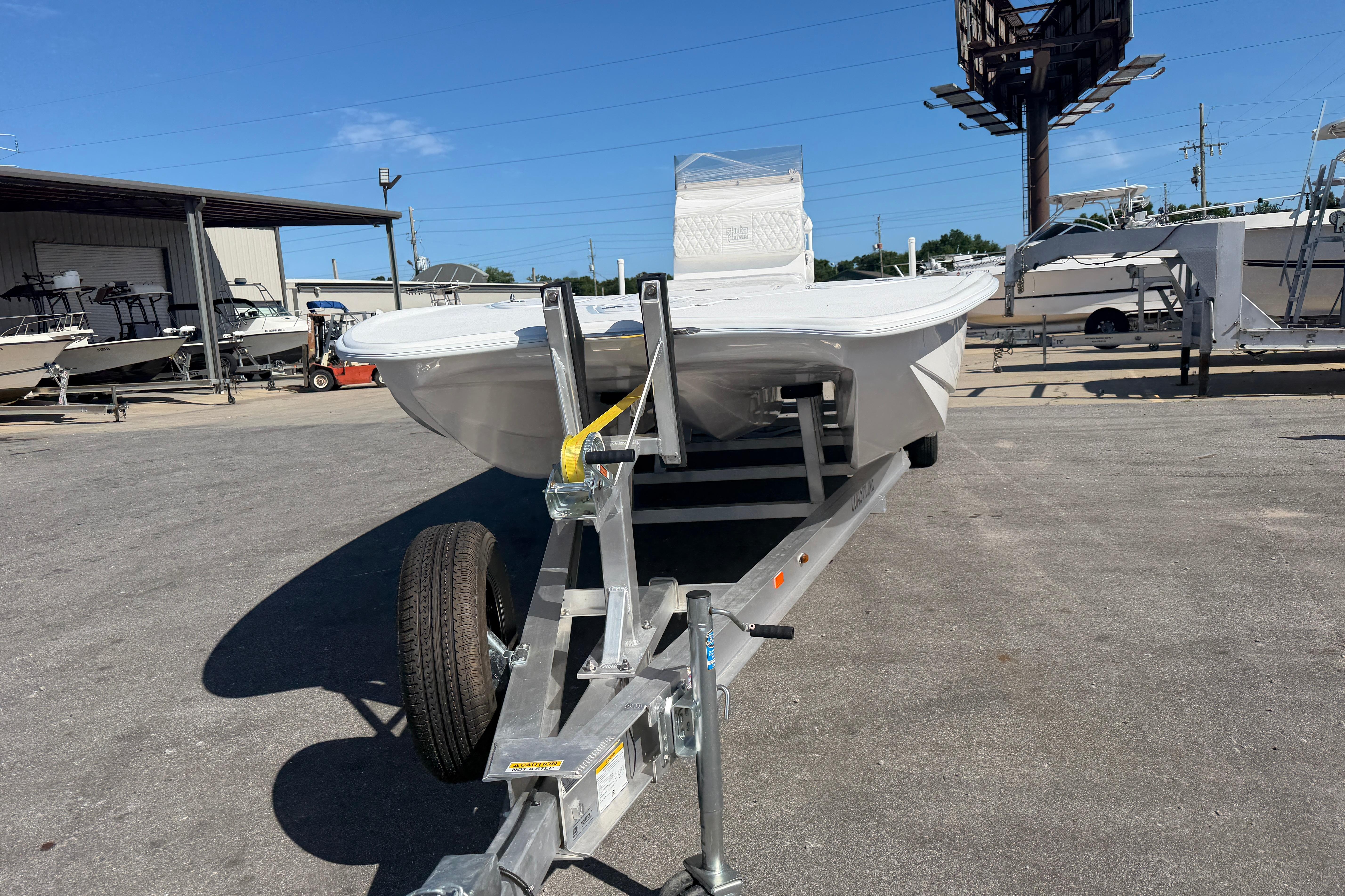 2026 Skuta 24 Cat boat on trailer in outdoor dealership lot.