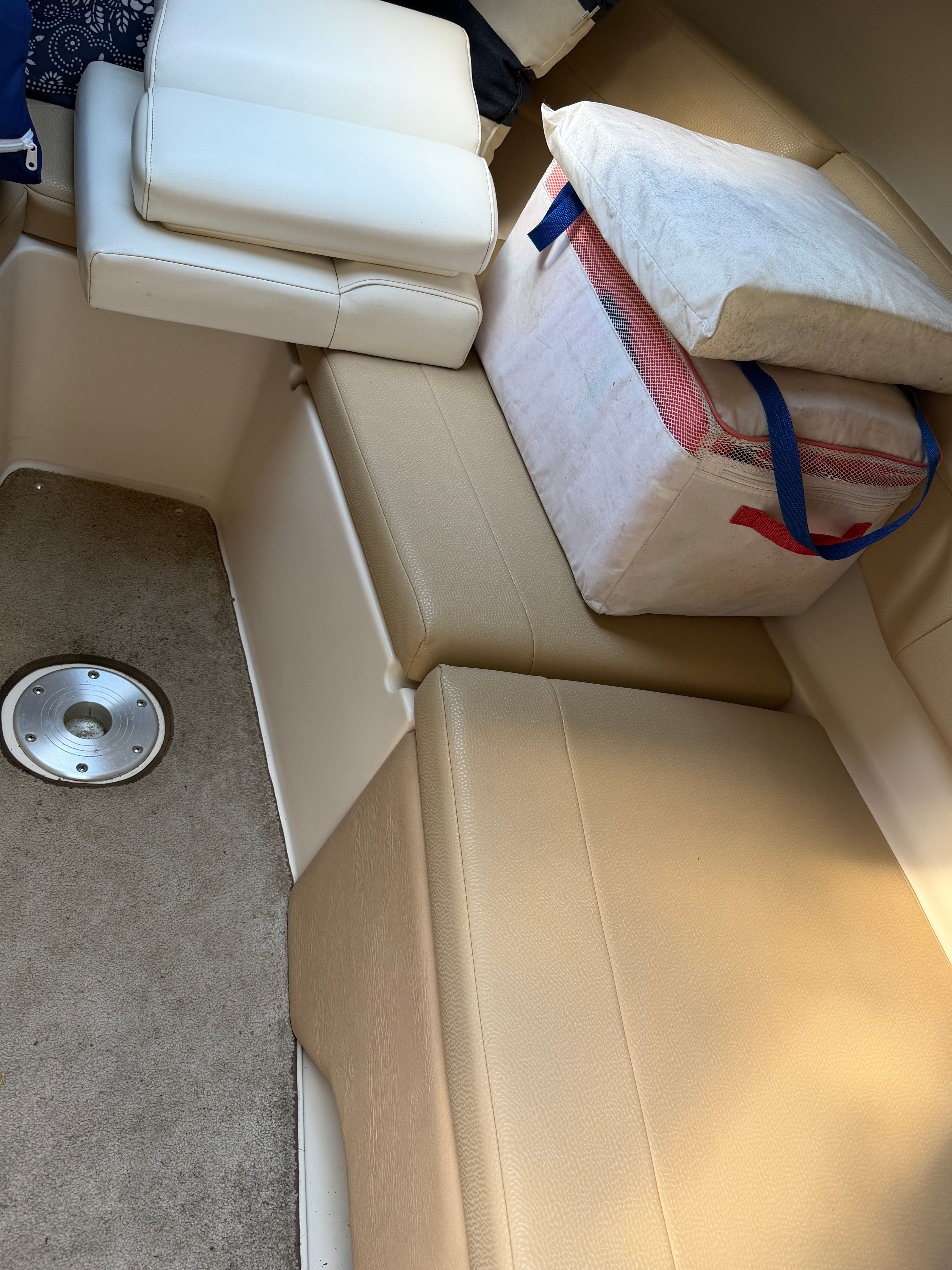 Interior of a 2011 Regal 2750 Cuddy with beige upholstery and a white cushion.