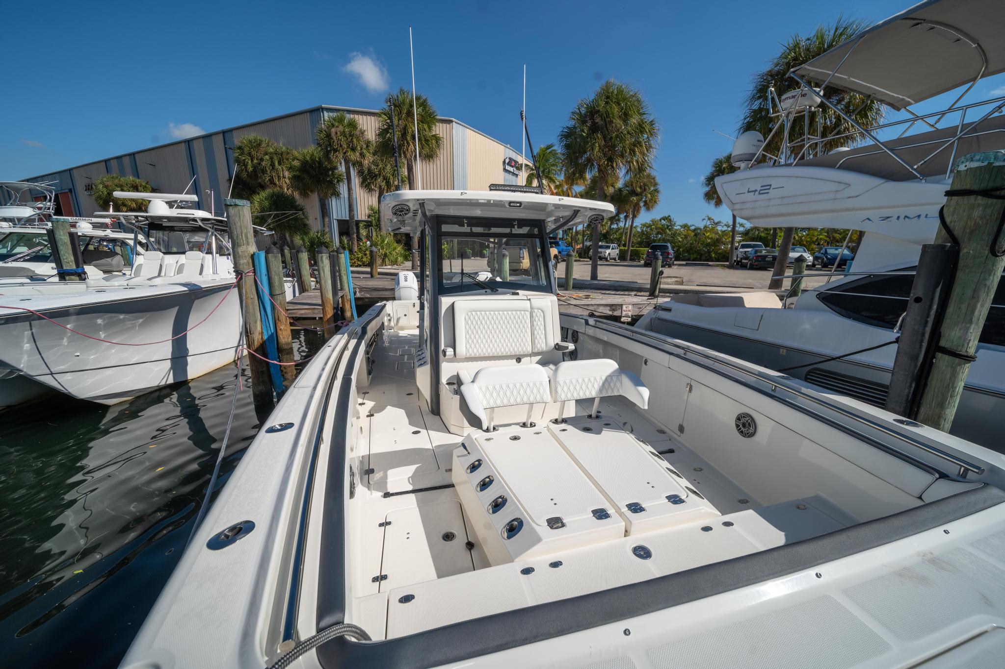 2022 World Cat 400 CC-X boat docked at marina under clear blue sky.