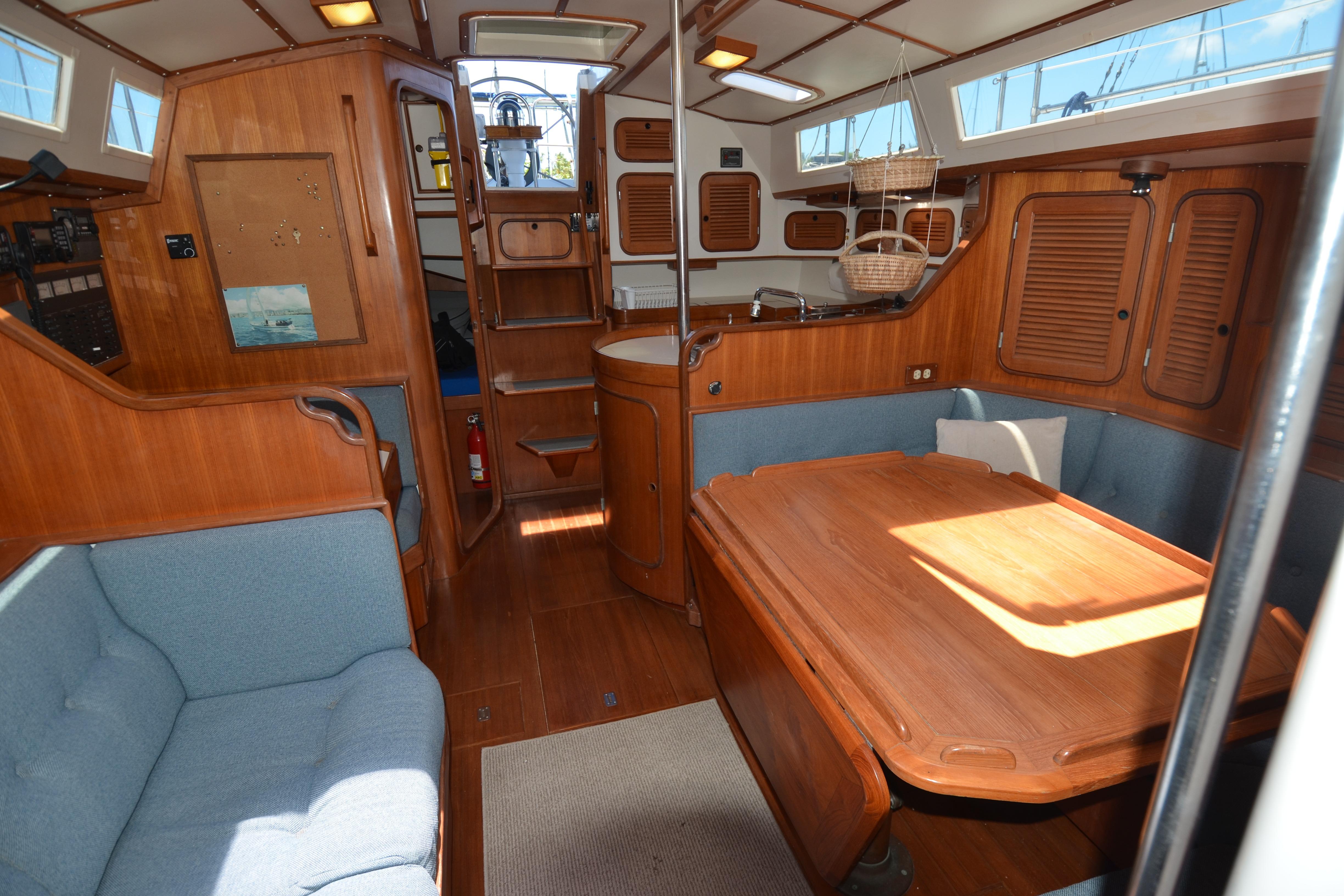 Interior of 1987 Norseman 400 sailboat with wooden furnishings and cozy seating area.