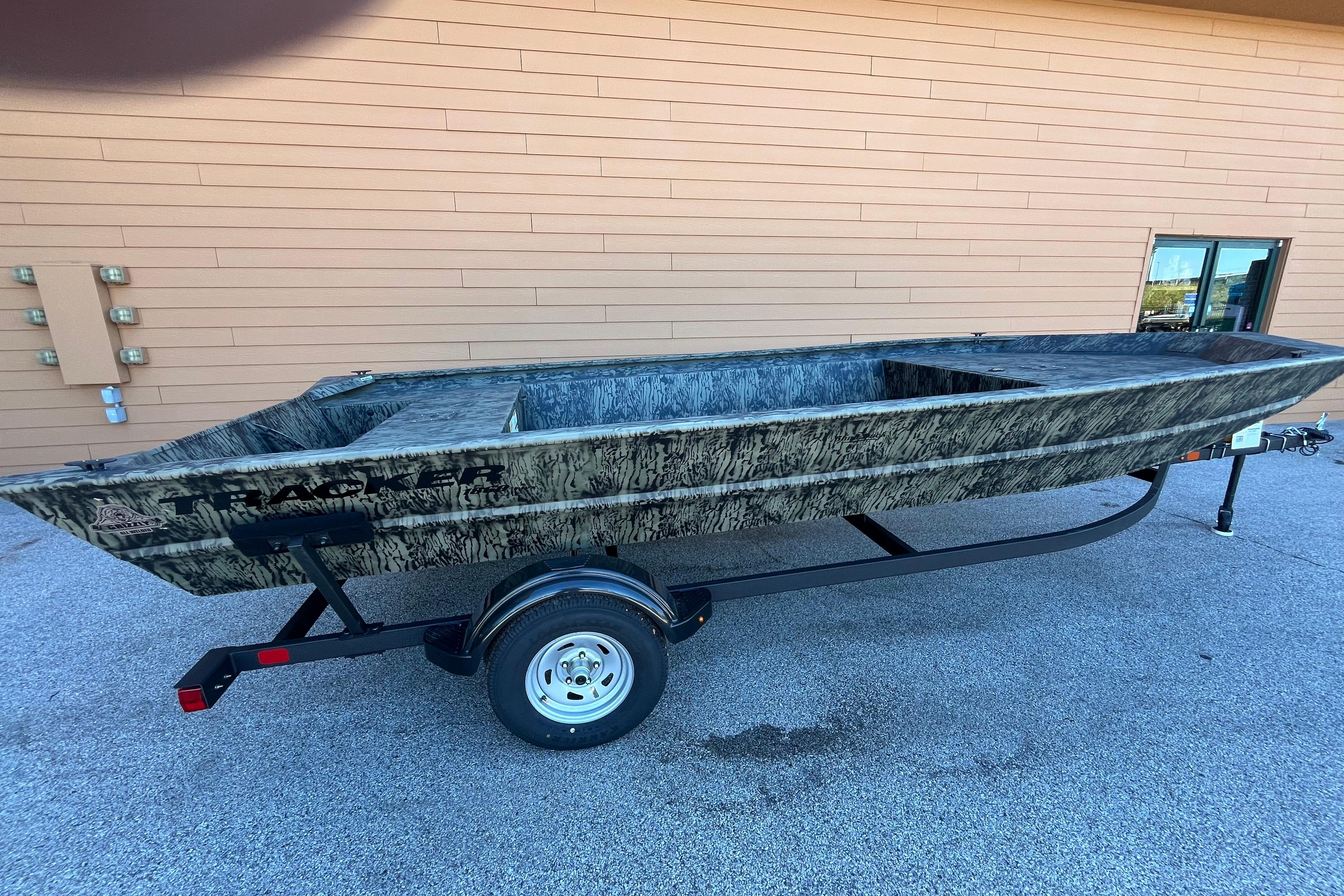 2026 Tracker GRIZZLY 1860 Utility boat on trailer, parked outdoors.
