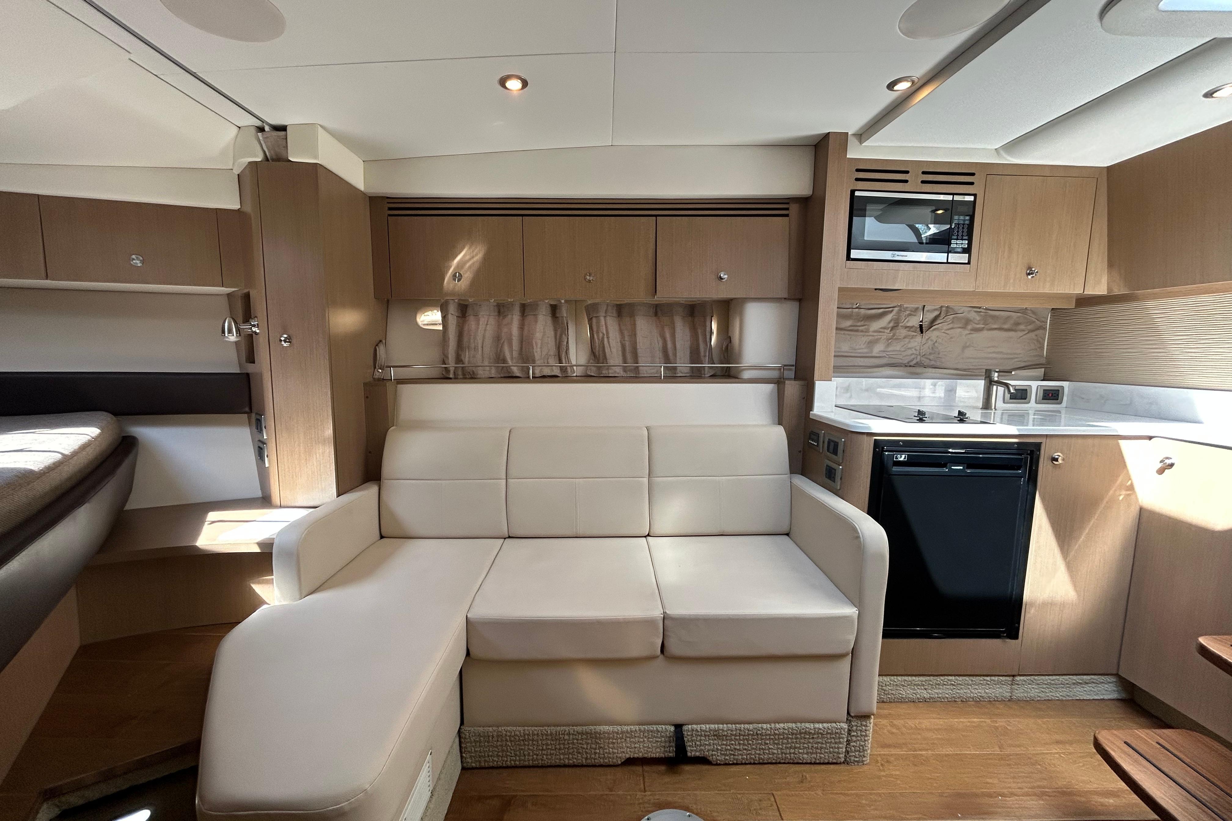 Luxurious interior of 2019 Sea Ray Sundancer 350 yacht with modern kitchen and seating area.