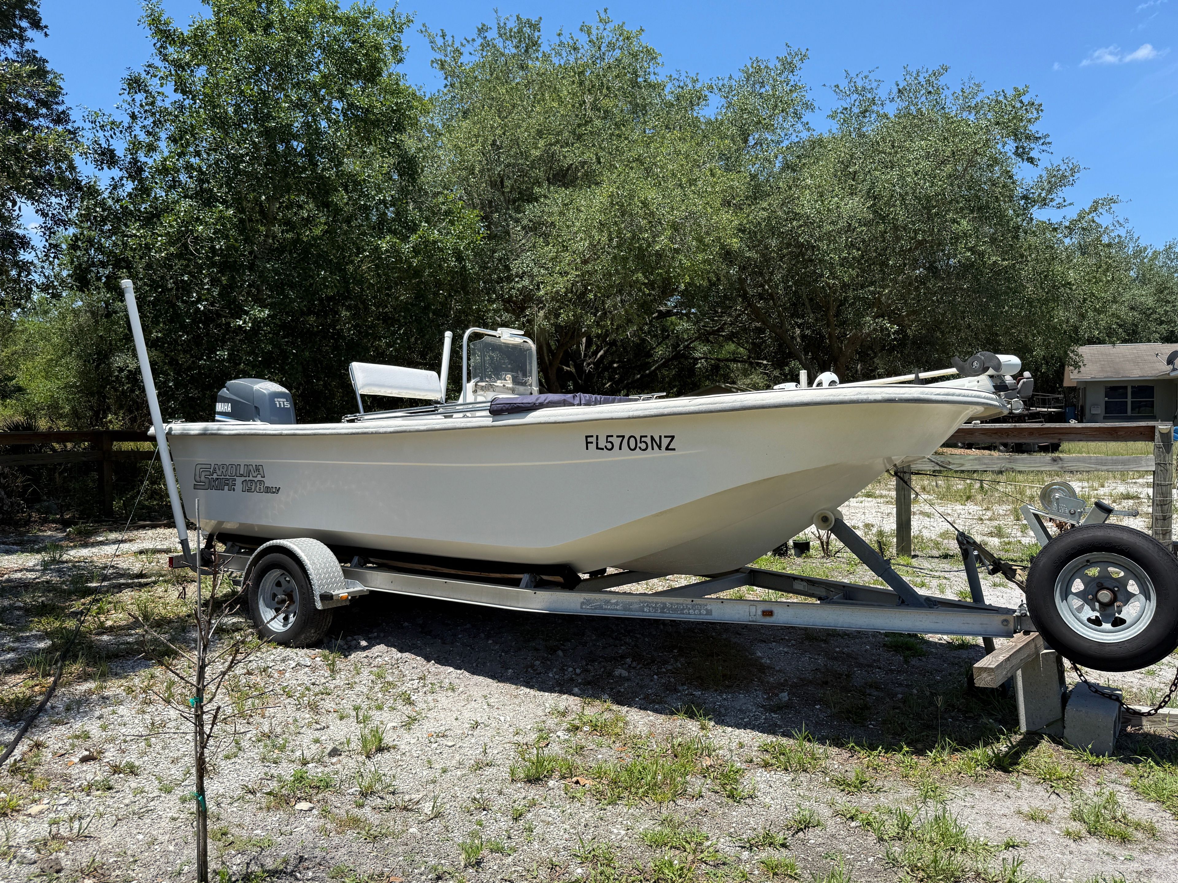 A 2008 Carolina Skiff 198 DLV on a trailer, surrounded by trees.