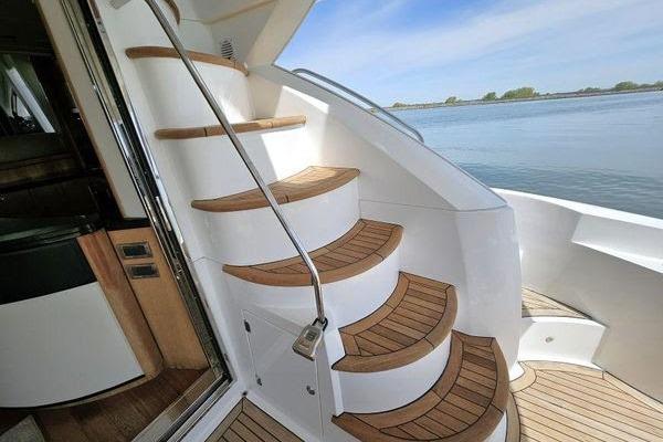 Staircase on 2005 Sunseeker Manhattan 66 yacht with wooden steps and ocean view.