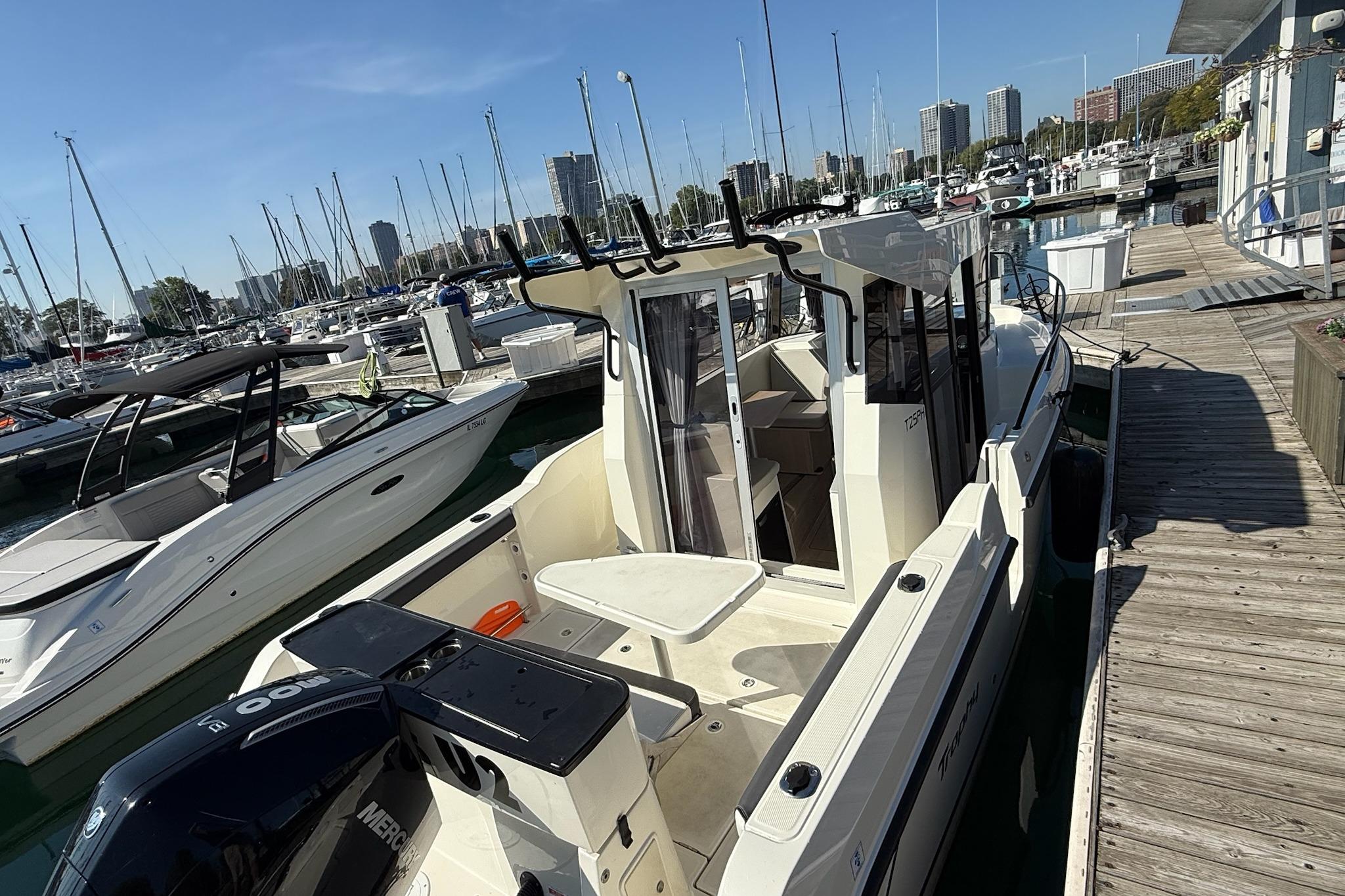 2024 Bayliner Trophy T25 Pilothouse docked at a marina with surrounding boats.
