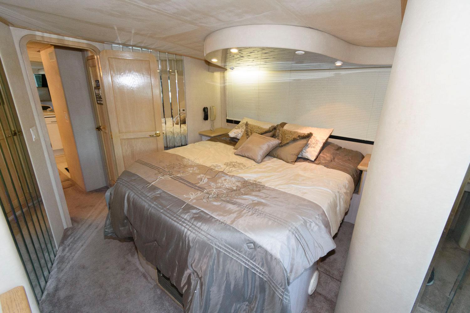 Luxurious bedroom in 1997 Bluewater Yachts 680 Custom Series with plush bedding and modern lighting.