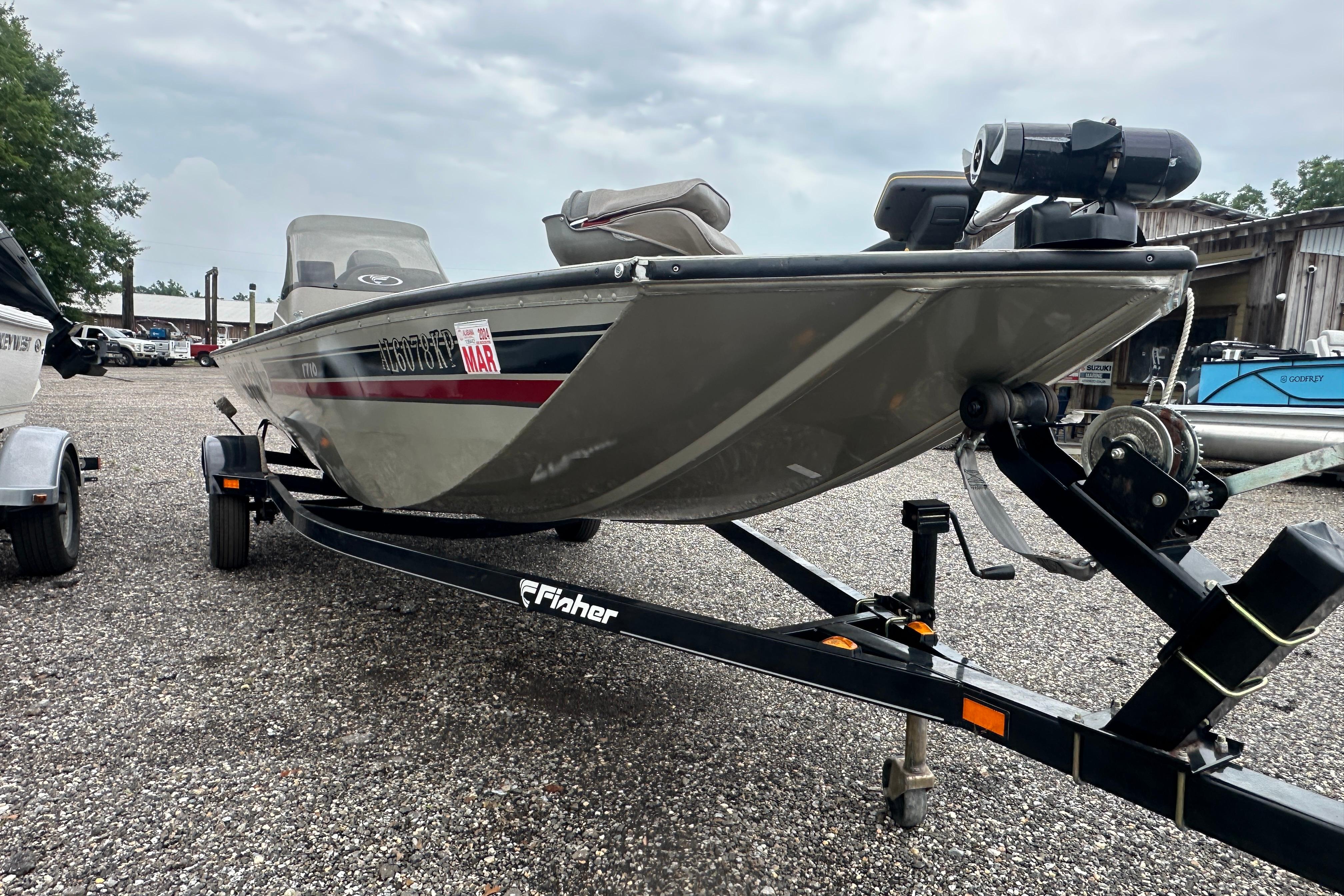 2002 Fisher 1710 boat on trailer, parked outdoors on gravel.