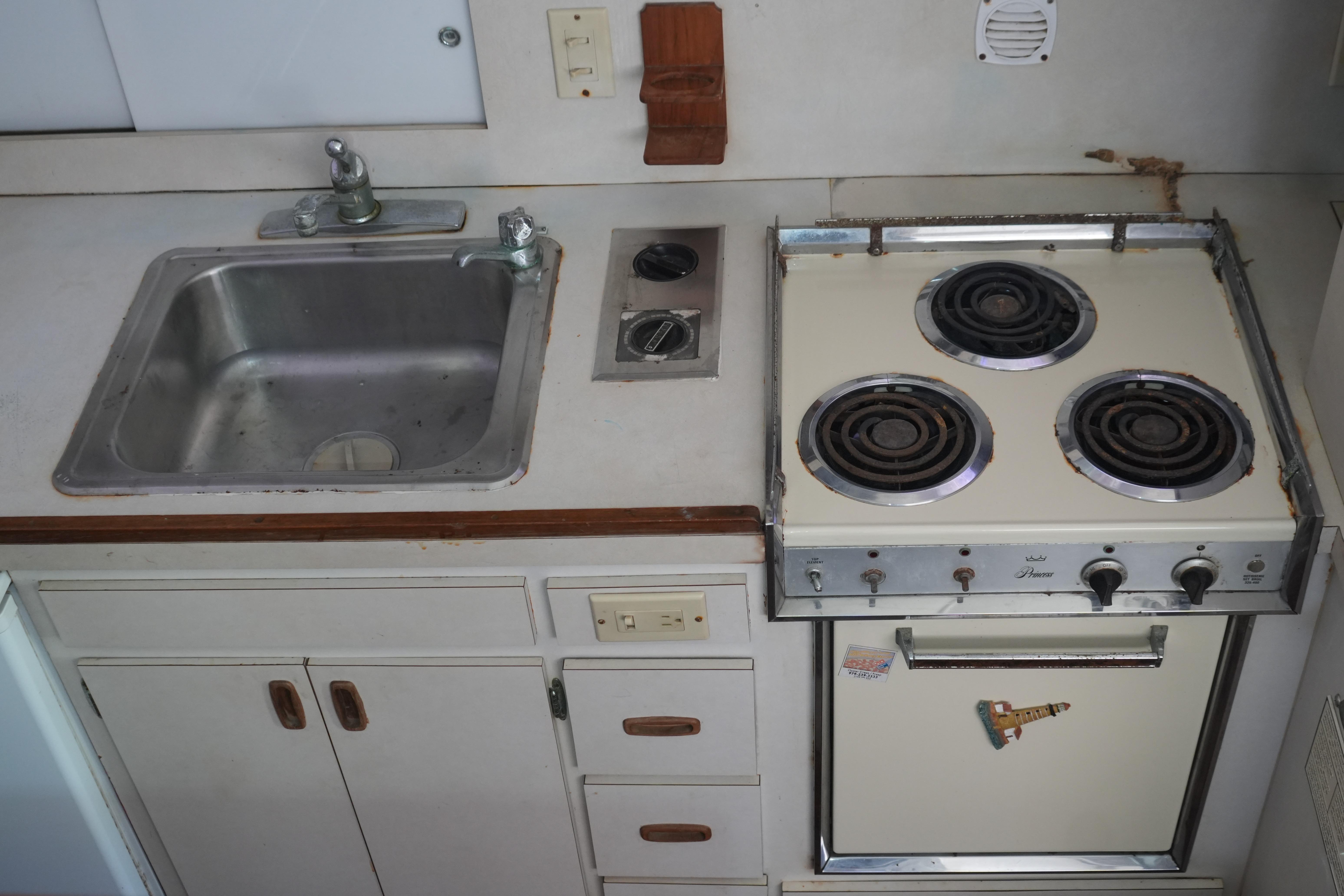 1977 Bertram 46.6 yacht kitchen with sink and vintage stove.