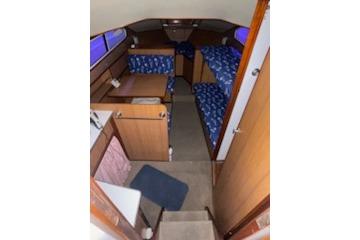 1964 Striker Model 120 boat interior with wooden furnishings and blue-patterned seating.