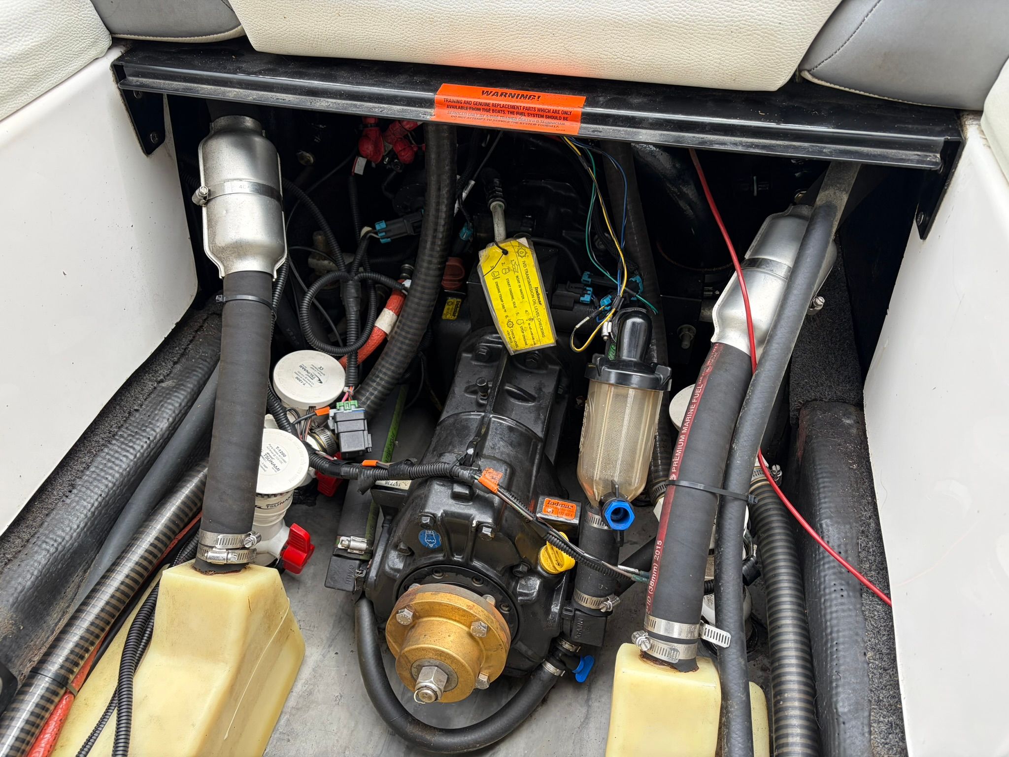 The engine compartment of a 2016 Tigé RZ2 boat with visible hoses and wiring.