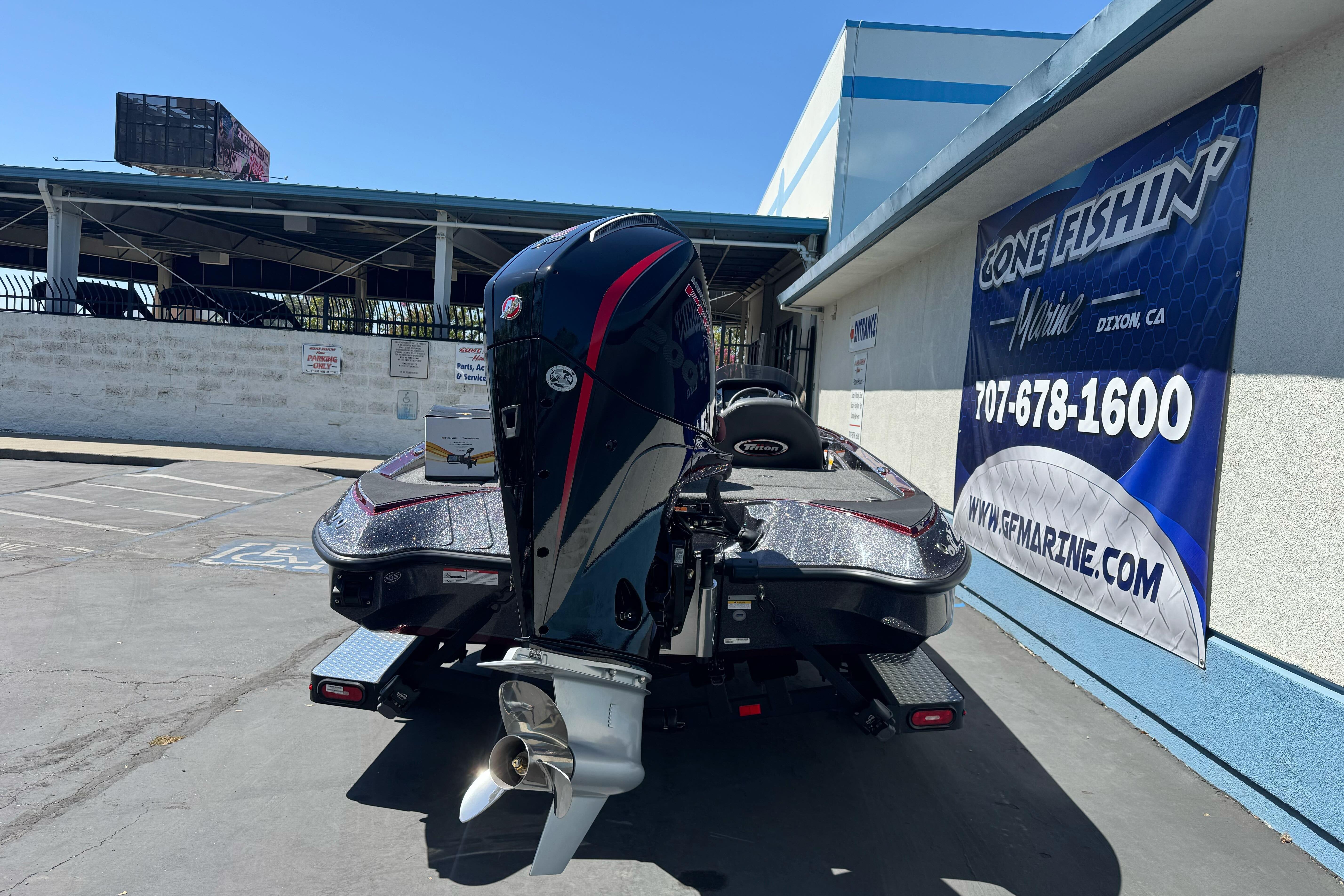 2026 Triton 18 TrX boat with powerful outboard motor, parked at a marine dealership.