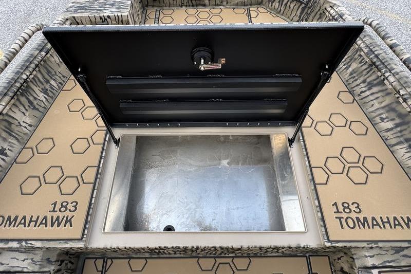 Open storage compartment on 2026 Excel 183 Tomahawk boat with hexagonal pattern design.