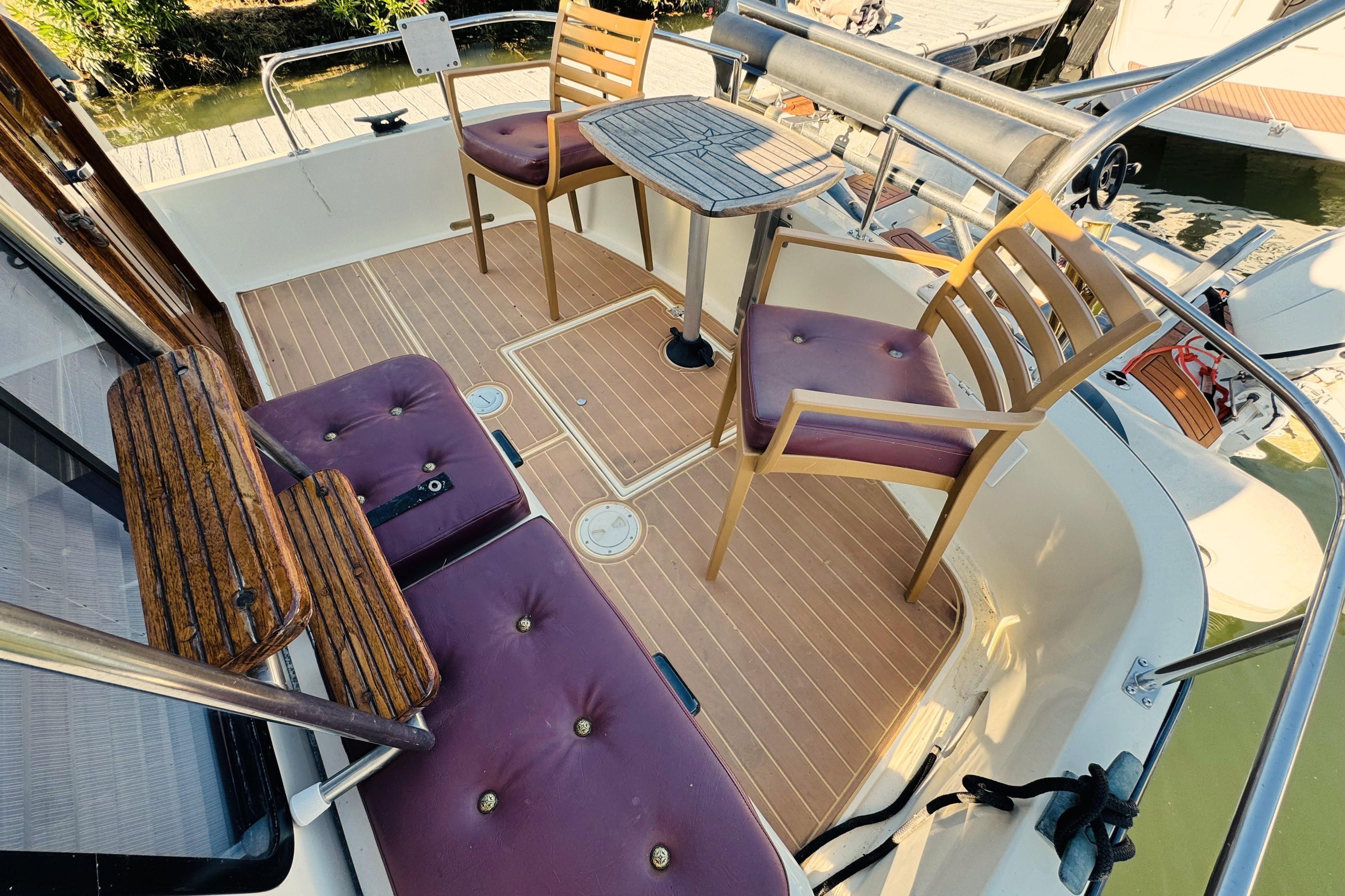 1996 Nordic Tug 32 boat deck with wooden chairs and table setup.