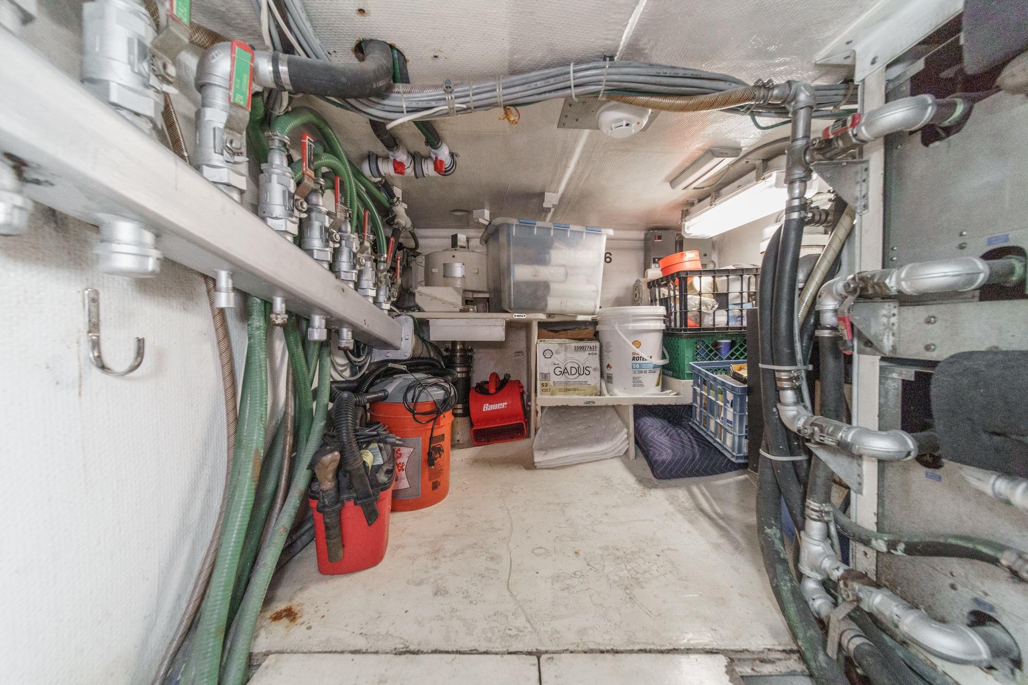 Engine room of a 1990 Seaton Long Range Cruiser with pipes and storage containers.
