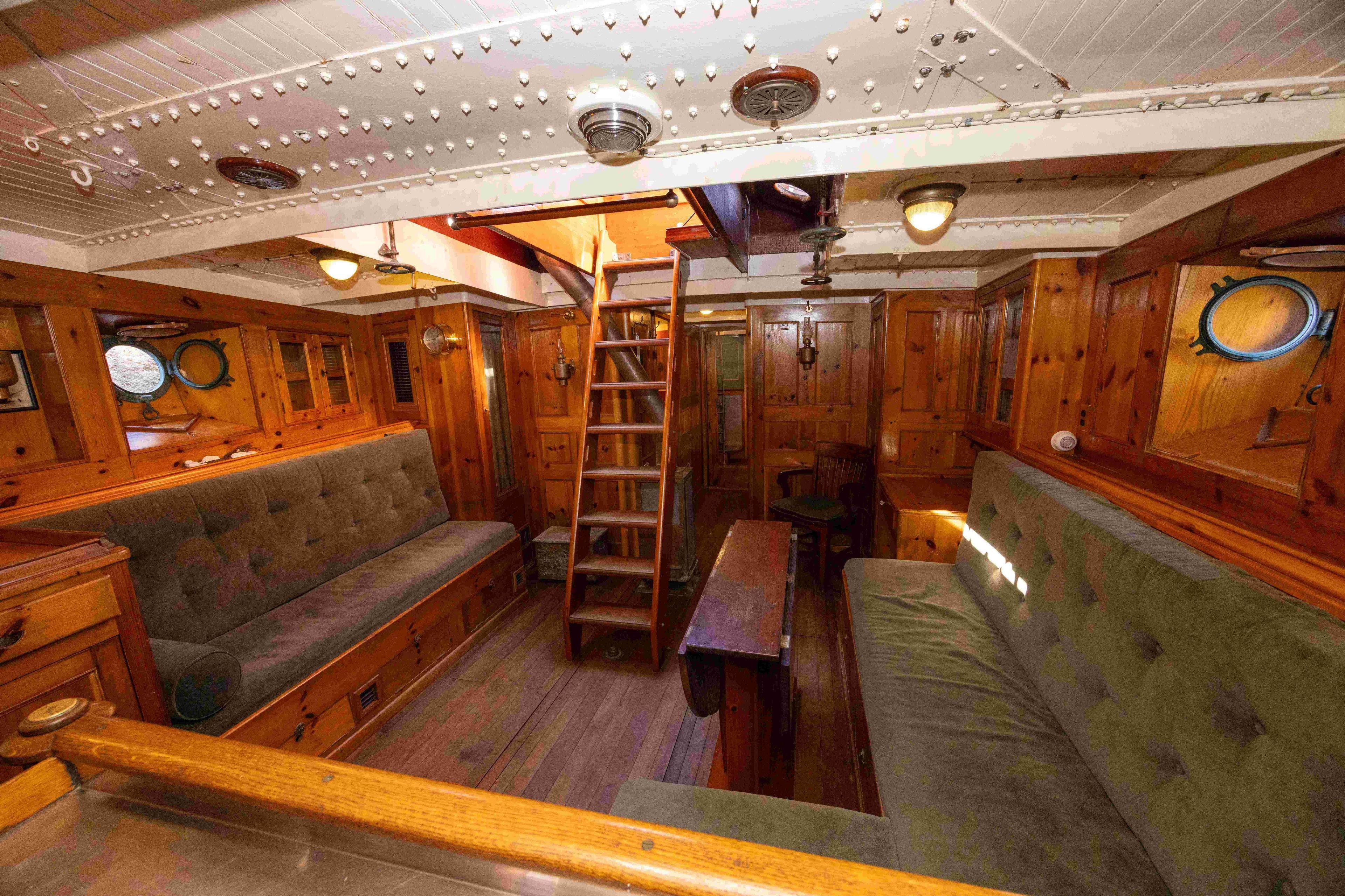 Interior of 1950 Abeking & Rasmussen Bespoke Motorsailer Yacht with wooden paneling and seating.